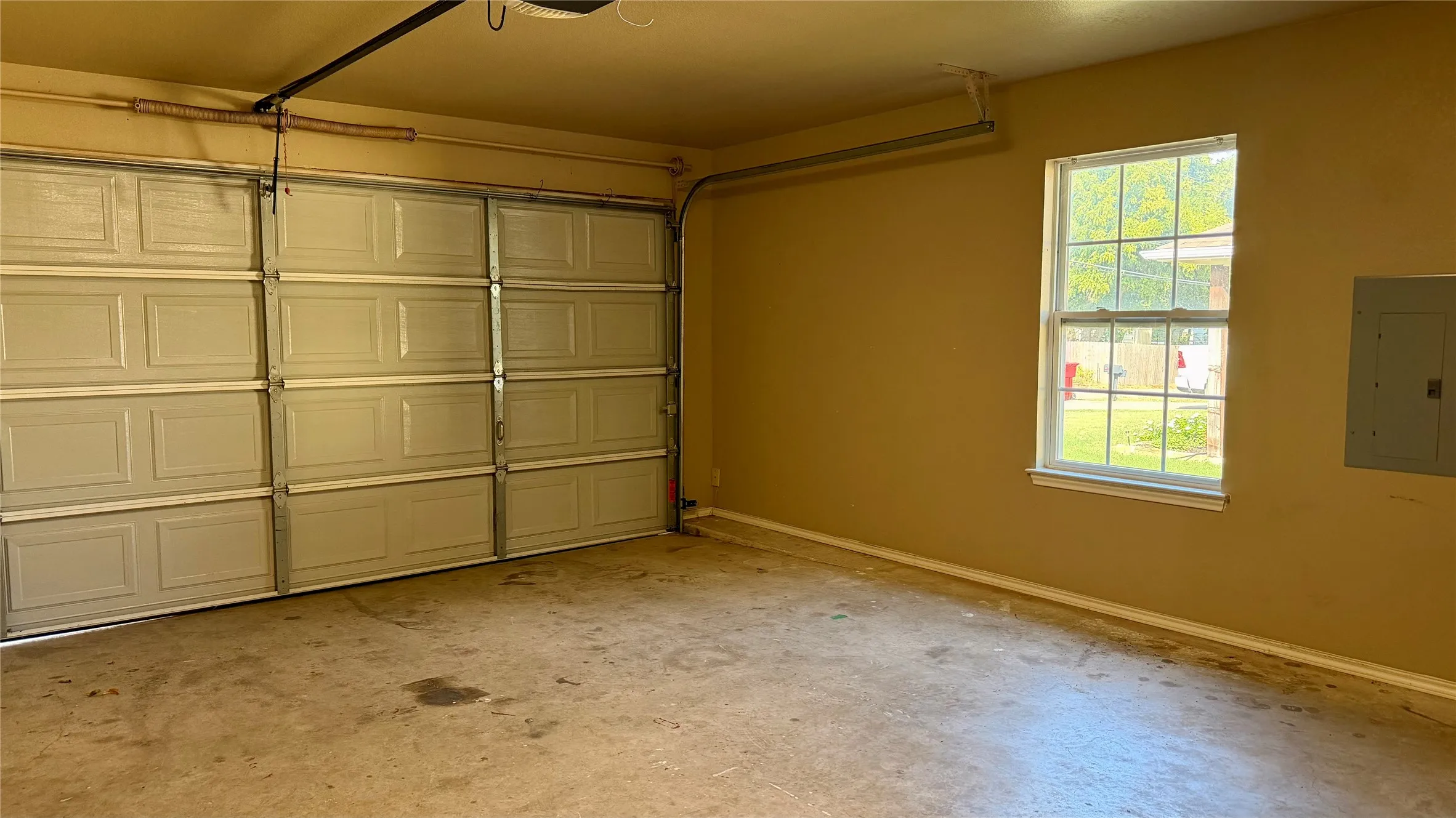 Two-car garage featuring panel-style doors and a window for natural light