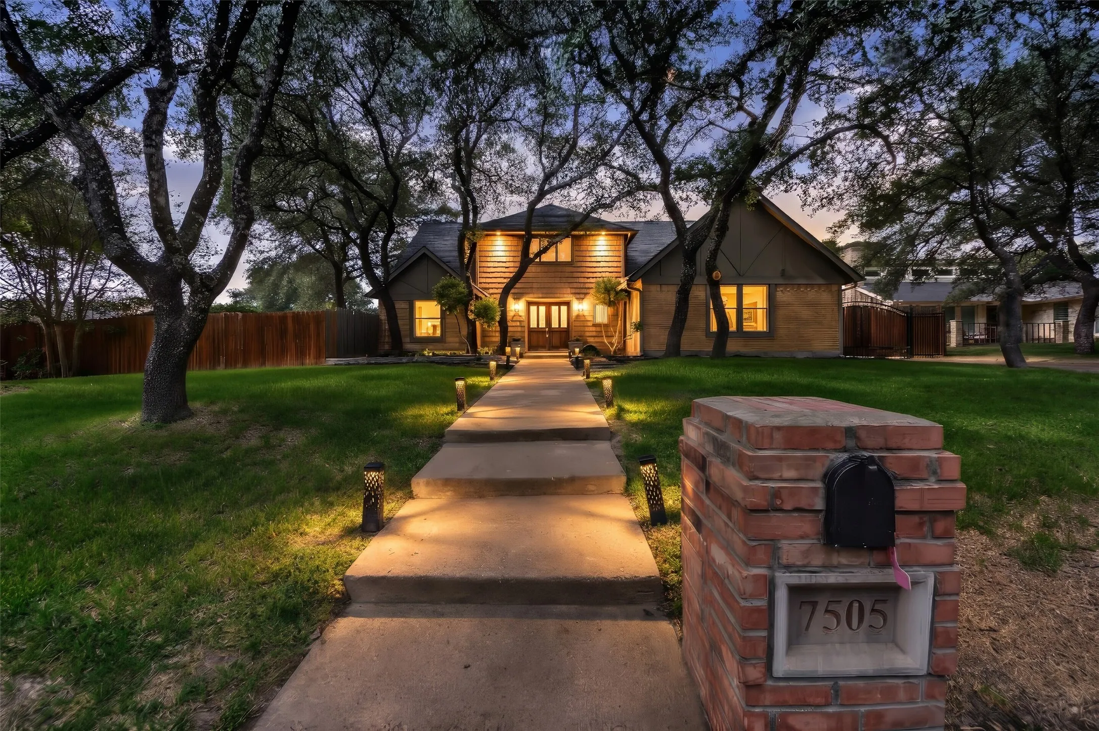 Wood-sided and stone-clad exterior with a concrete pathway