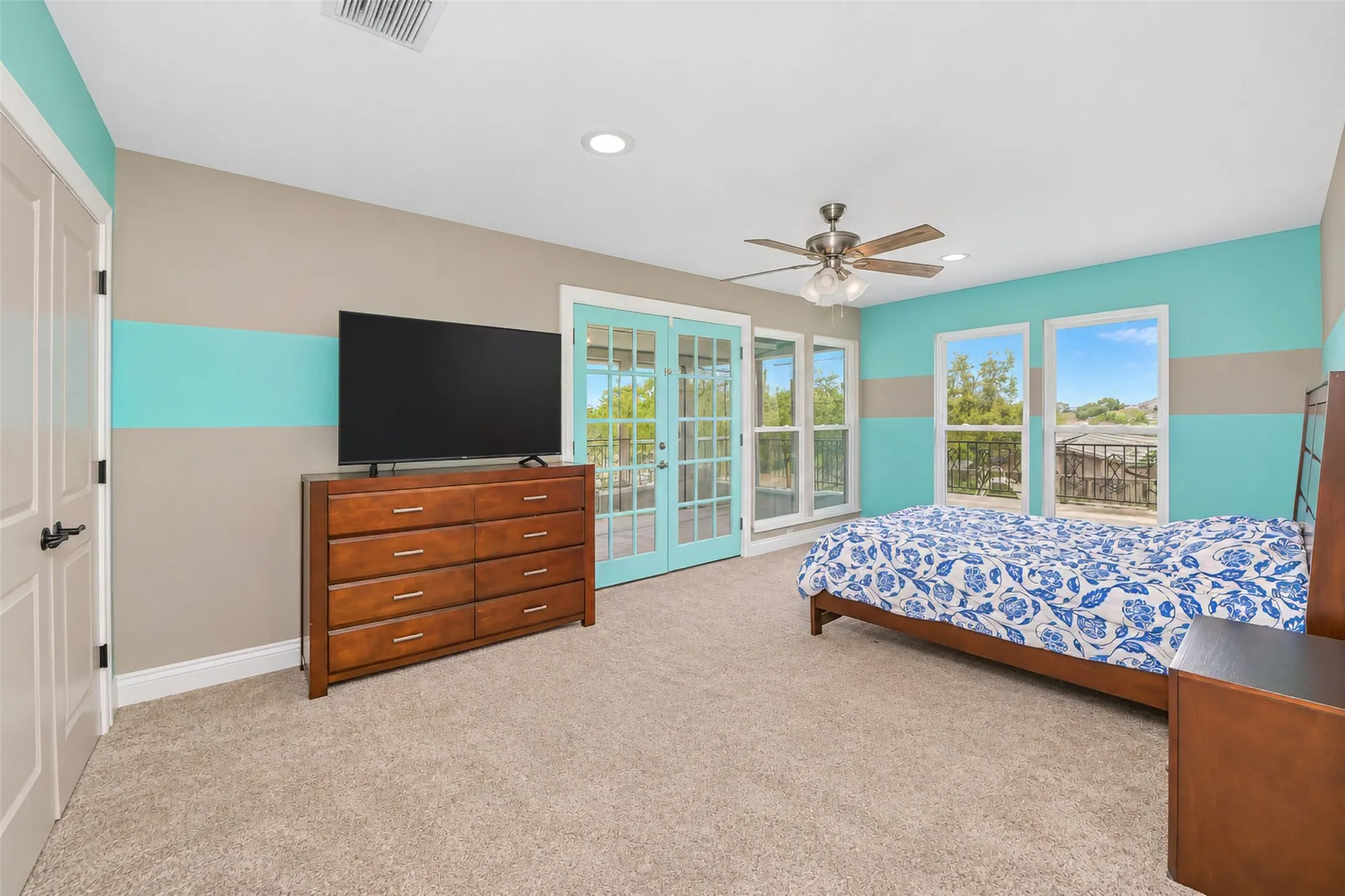 Recessed lighting, ceiling fan, and French doors with transom windows