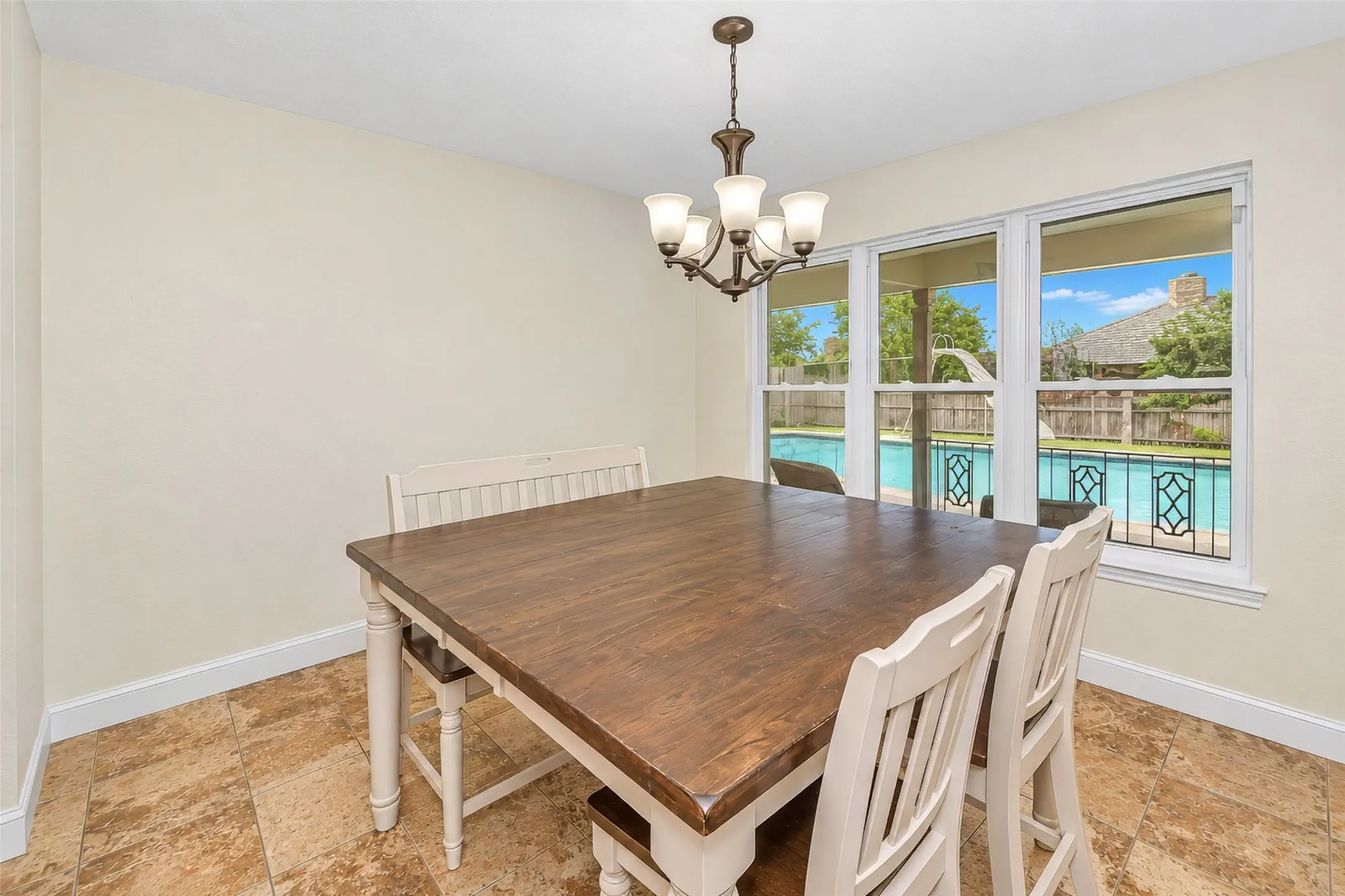 Tile flooring, multi-panel window, chandelier, and backyard pool