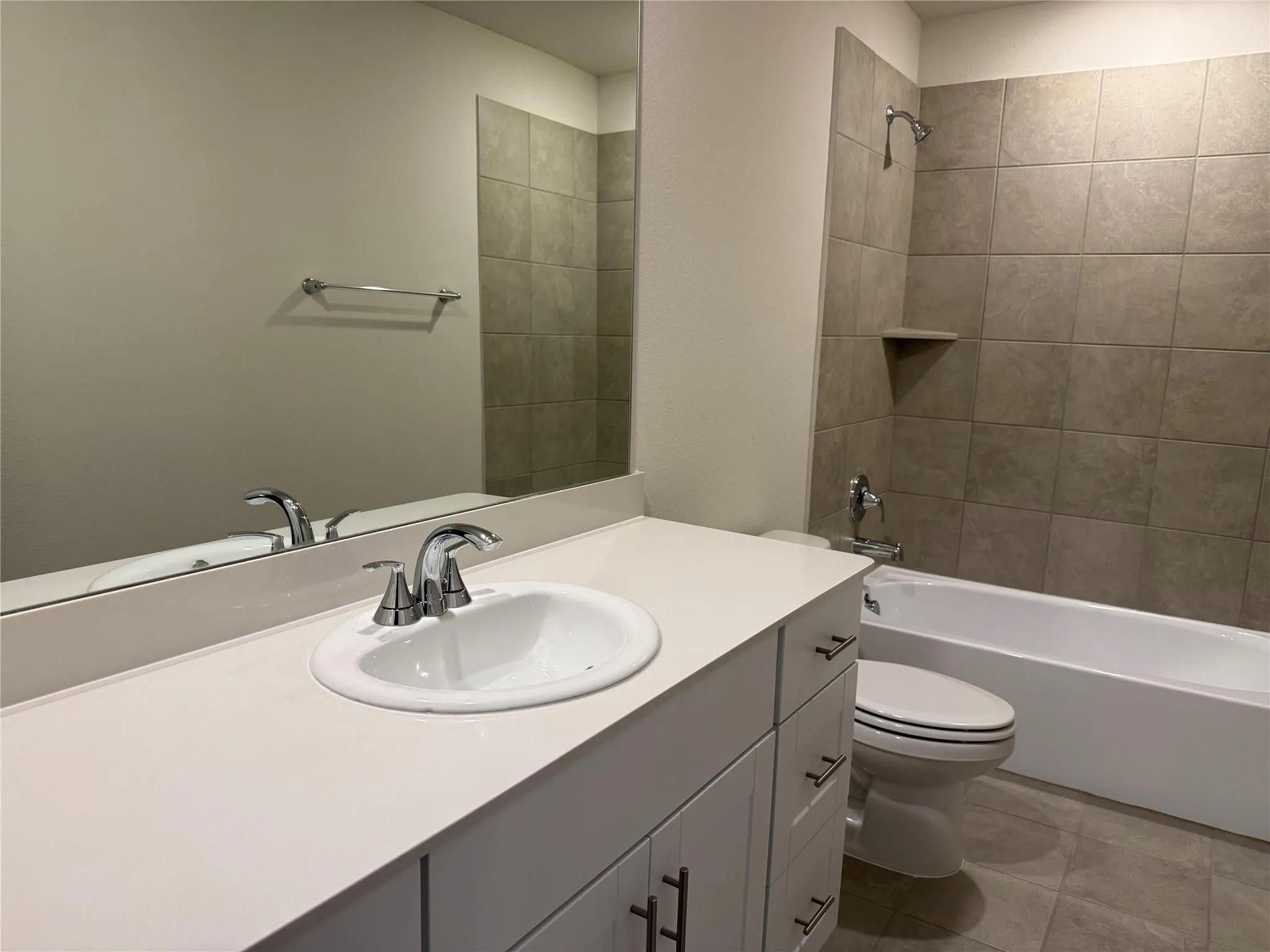 Bathroom featuring a white vanity with a light-colored countertop, an integrated sink, and chrome fixtures