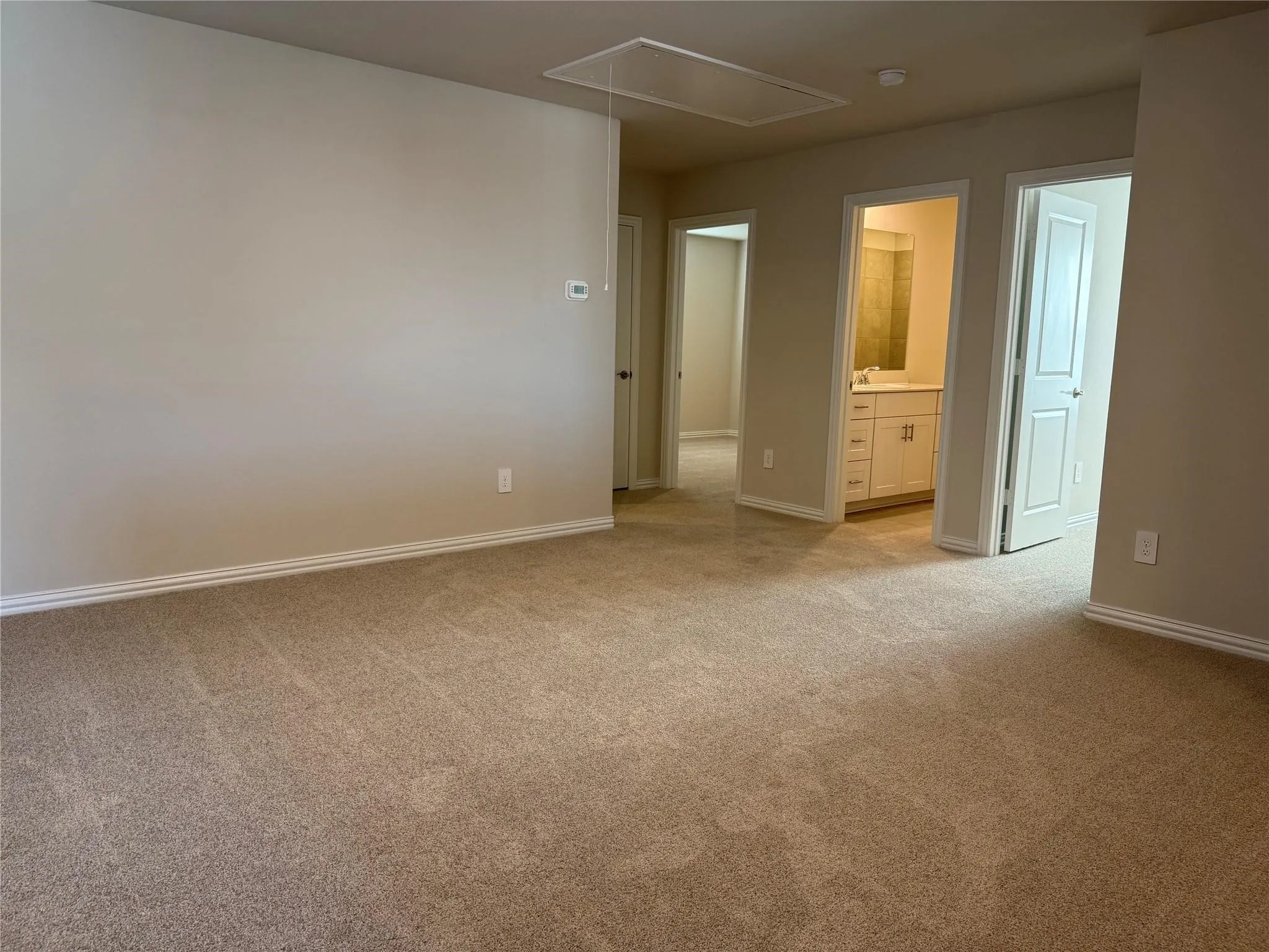 Neutral-toned walls complement the carpeted flooring