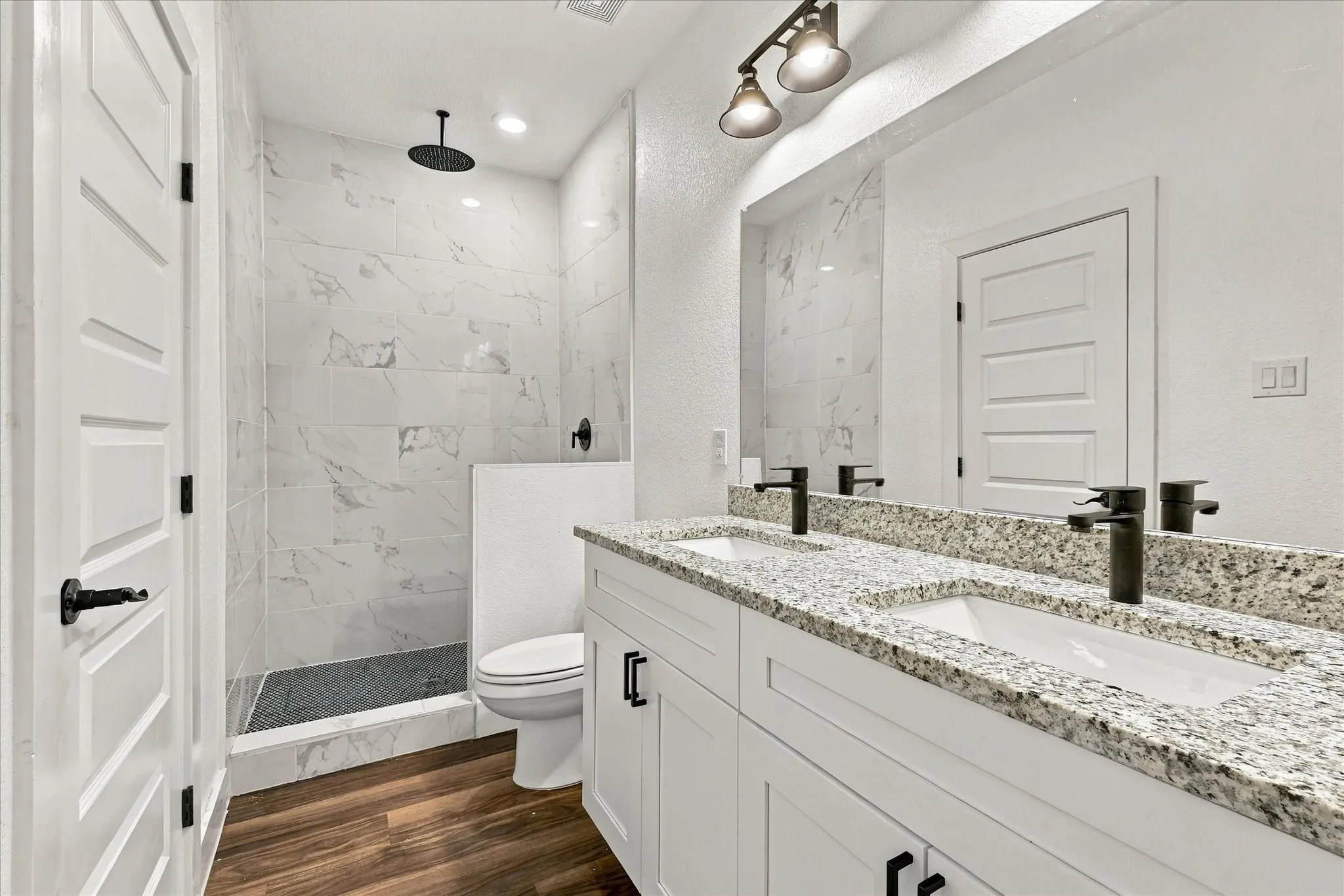 Double vanity with granite countertop, undermount sinks, and matte black fixtures