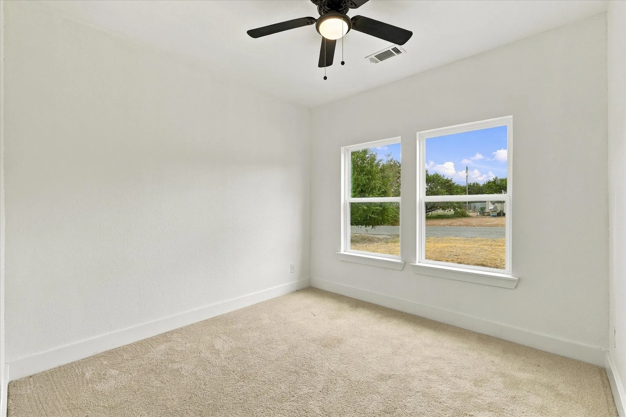 Recessed lighting, ceiling fan fixture, dual windows, and light-toned carpeting