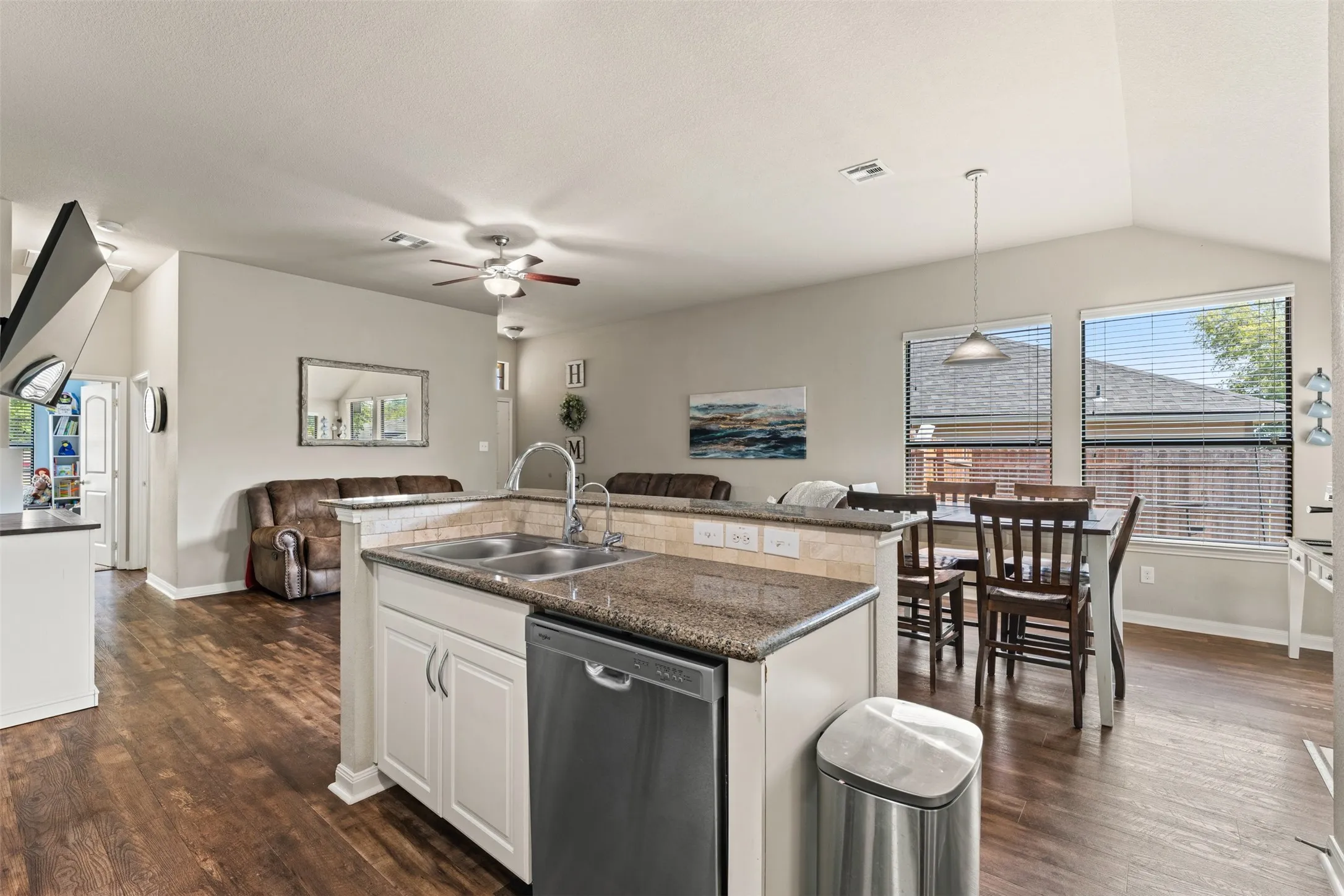 Kitchen island with double basin sink, stainless steel dishwasher, and granite countertop