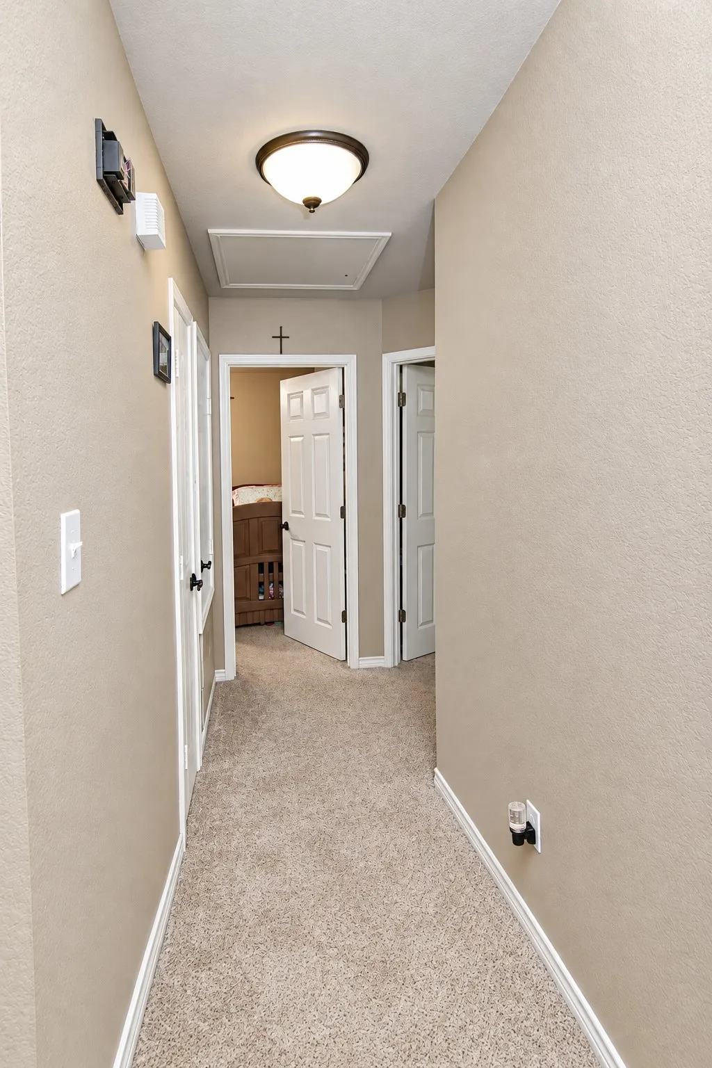 Neutral-toned walls with white trim, complementing the textured carpet flooring