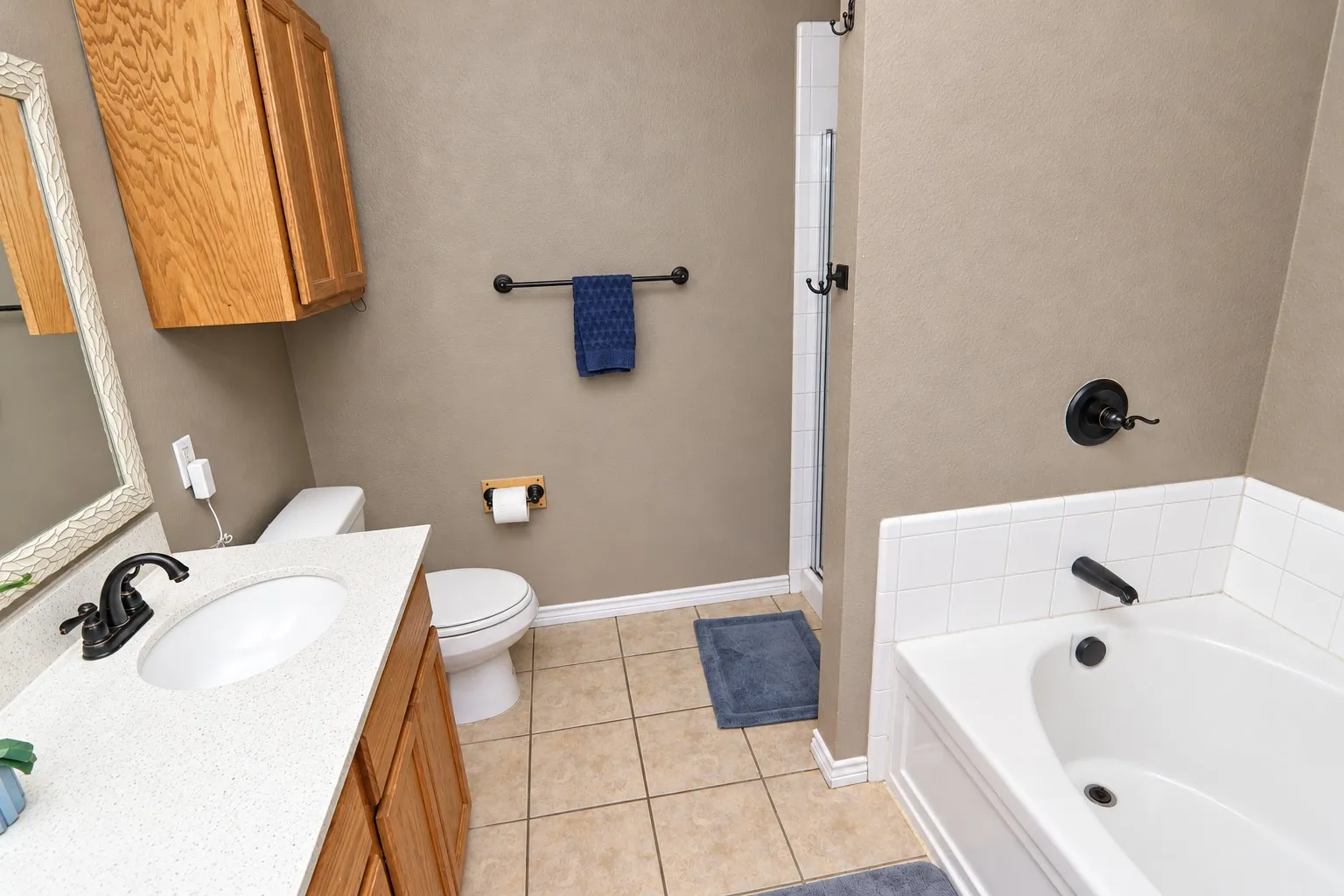 Integrated tub and shower combination with a glass enclosure