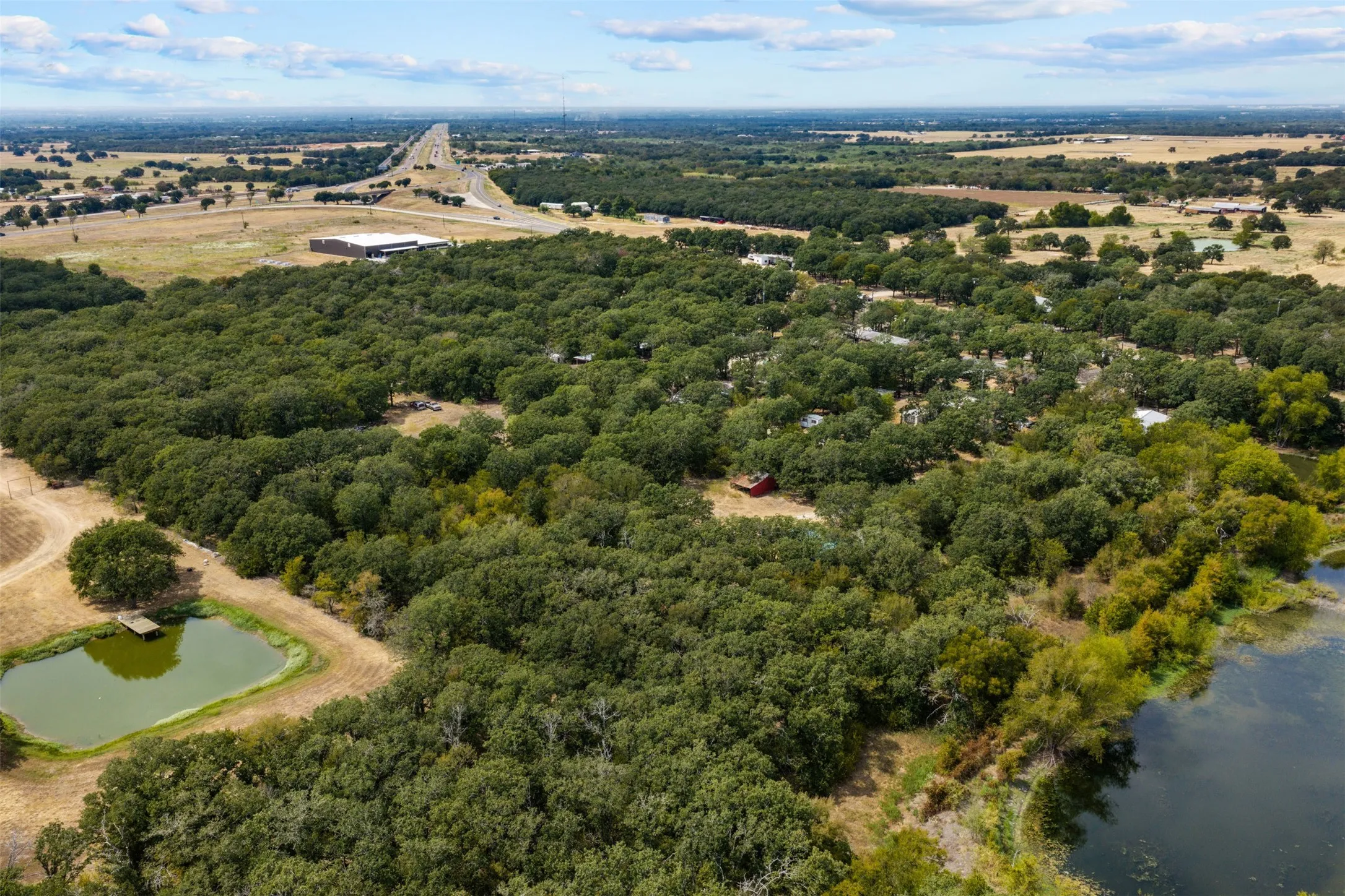 Expansive wooded acreage featuring two ponds and distant highway access