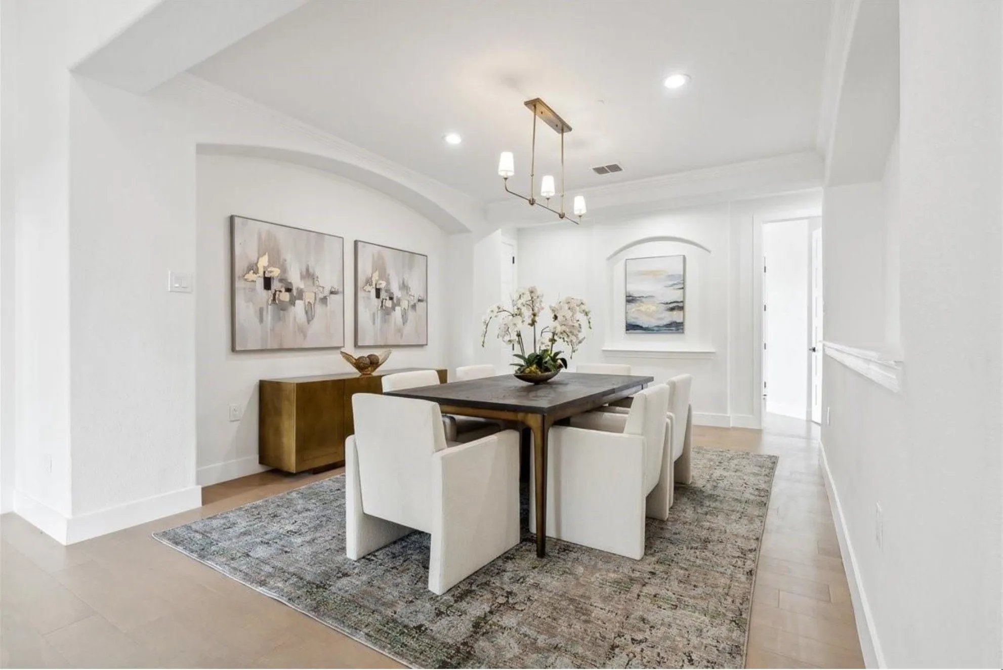 Recessed ceiling lighting, wood-finish flooring, and a modern linear chandelier