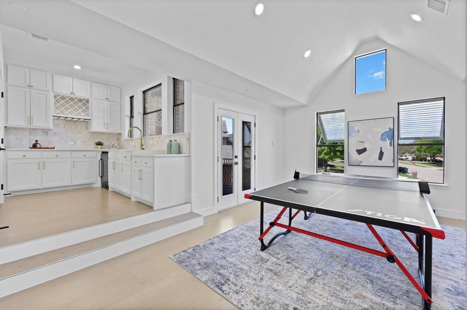 Integrated kitchen area with white cabinetry and a built-in wine rack