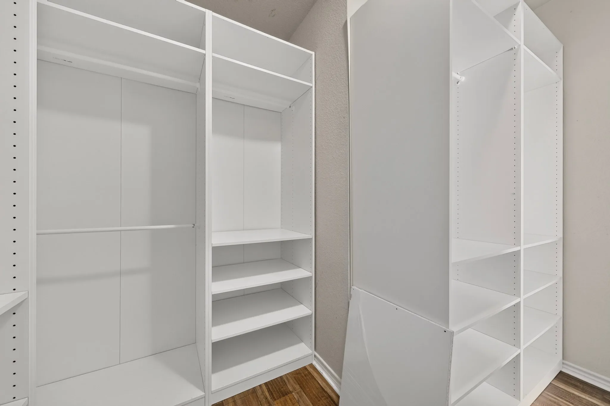 Walk-in primary bedroom's closet with lots of shelving!