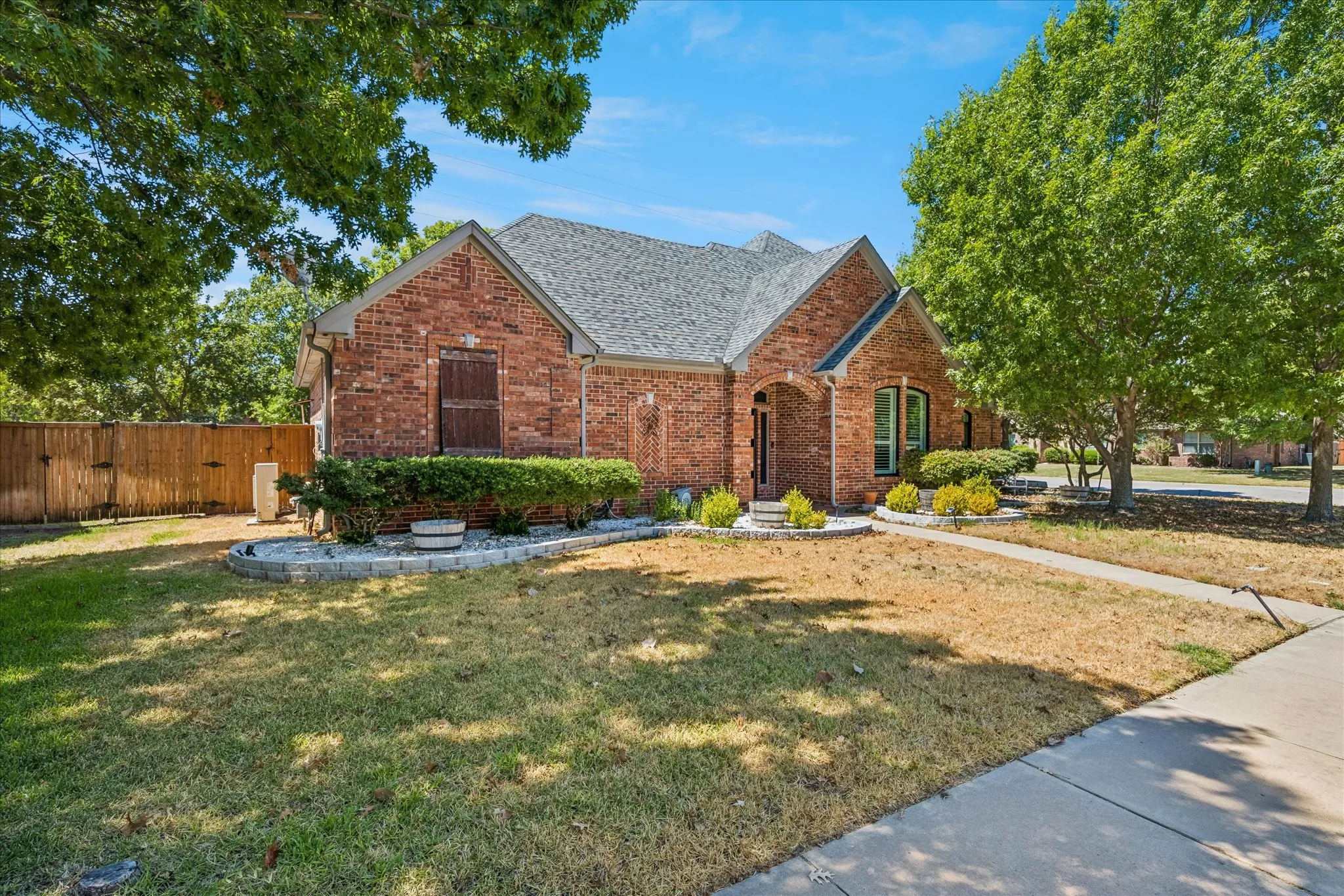 Brick exterior with a gray shingle roof and arched entryway