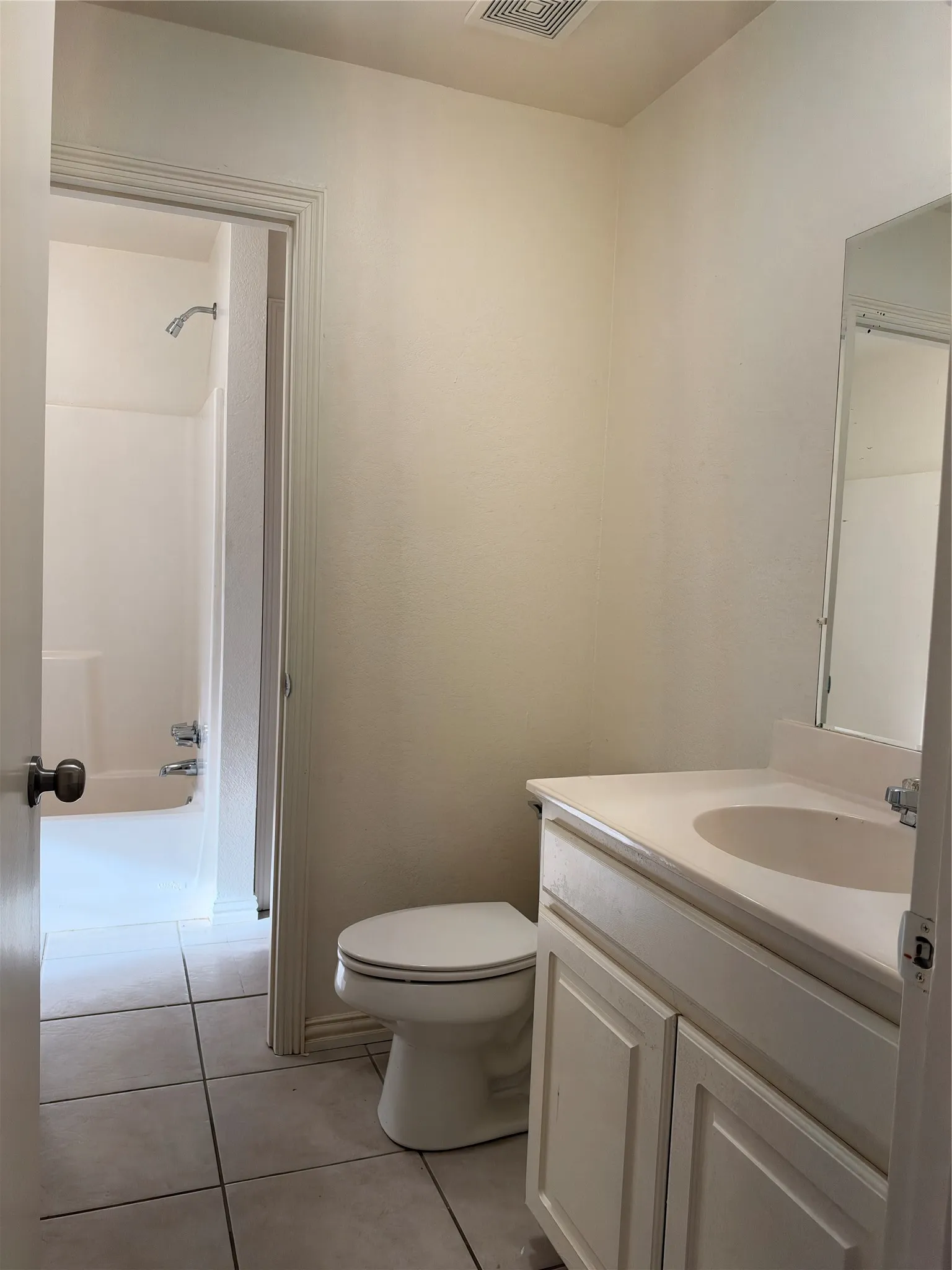 Bathroom featuring a single vanity with storage, tile flooring, and a shower-tub combination