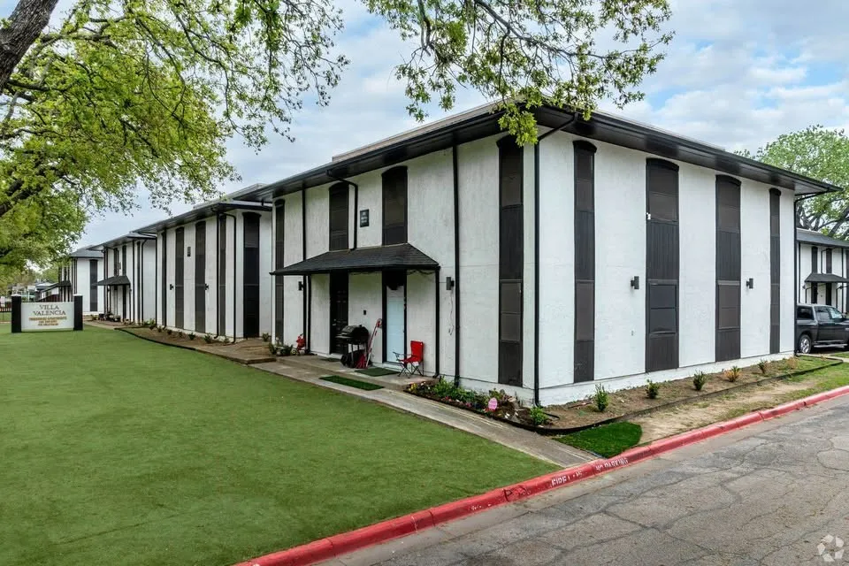 White exterior with black trim, covered entry, and black awnings