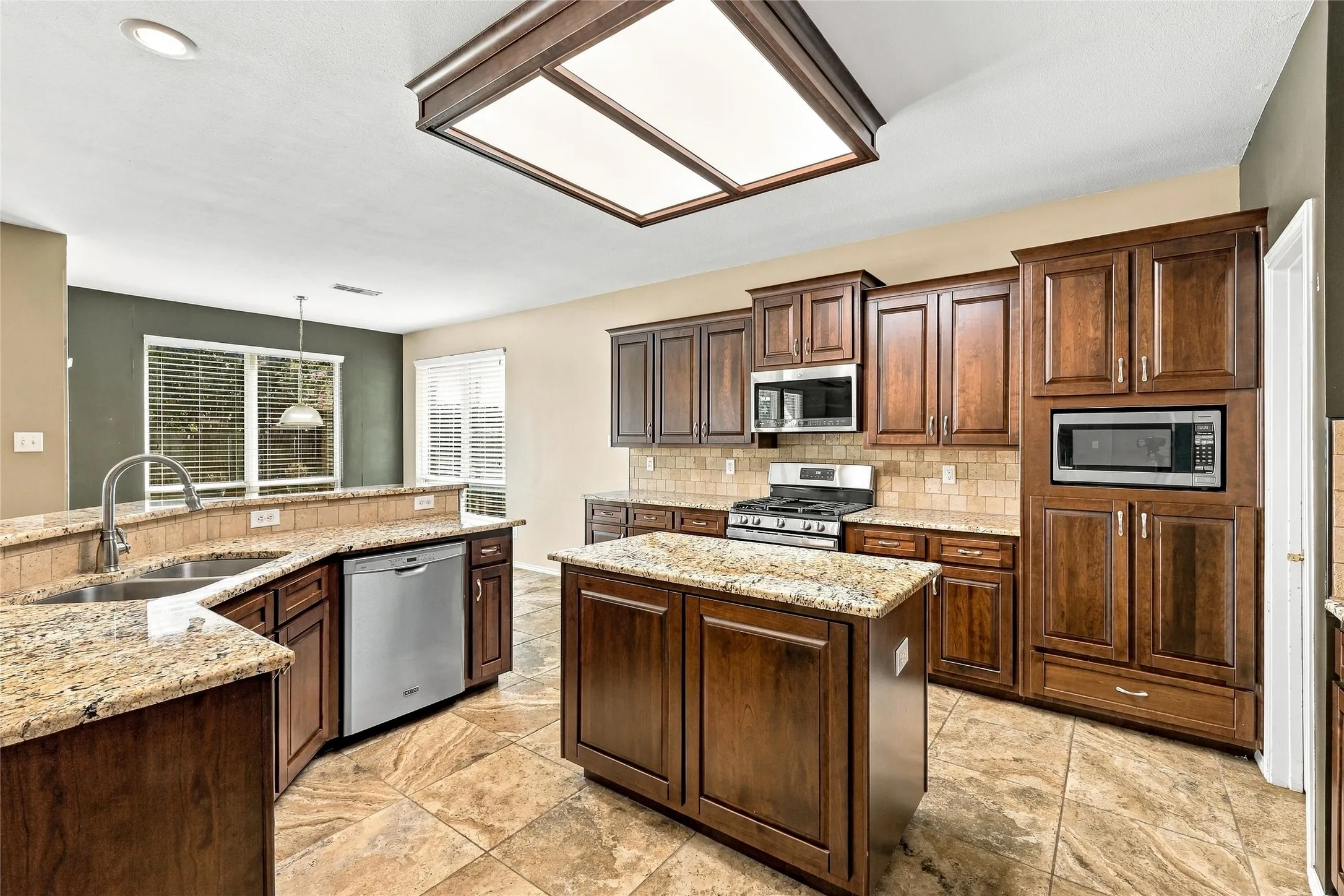 Kitchen is oversized and has island, granite counter tops, gas stove, stainless steal appliances