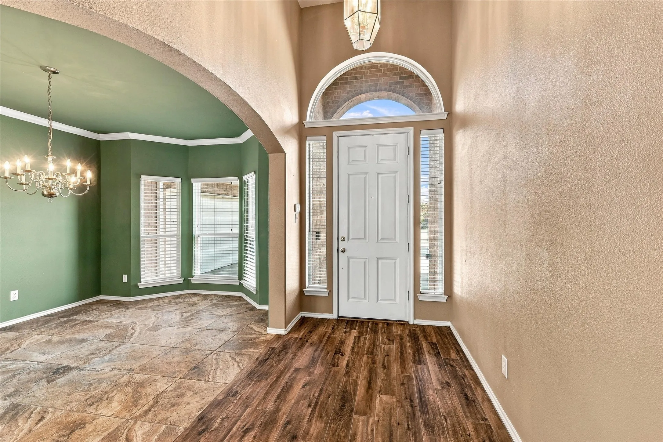 beautiful entry with tall ceilings opening to dining room