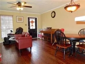 Wood-finish flooring throughout, ceiling fan with integrated lighting, and a pendant light fixture