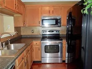 Warm wood cabinetry, stainless steel appliances, and a double basin sink