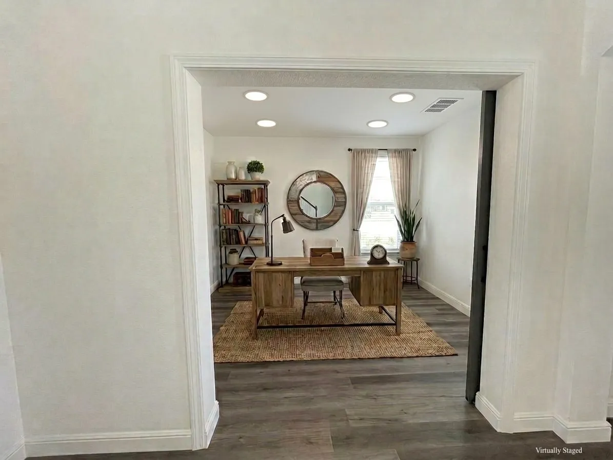 Recessed lighting illuminates the room, featuring wood-finish flooring and a window with natural light - VIRTUALLY STAGED