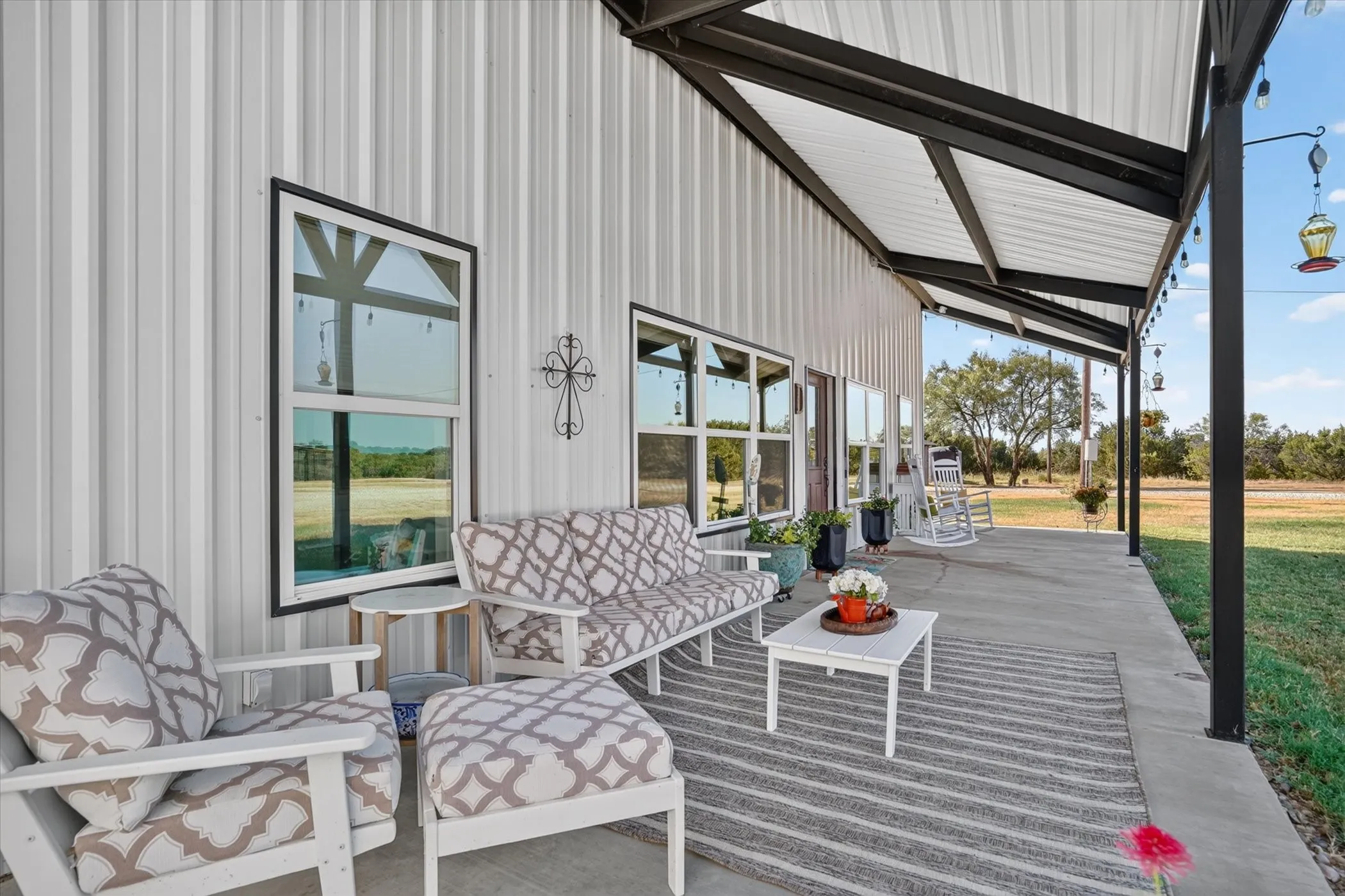 Expansive concrete patio with a metal awning, offering covered outdoor space