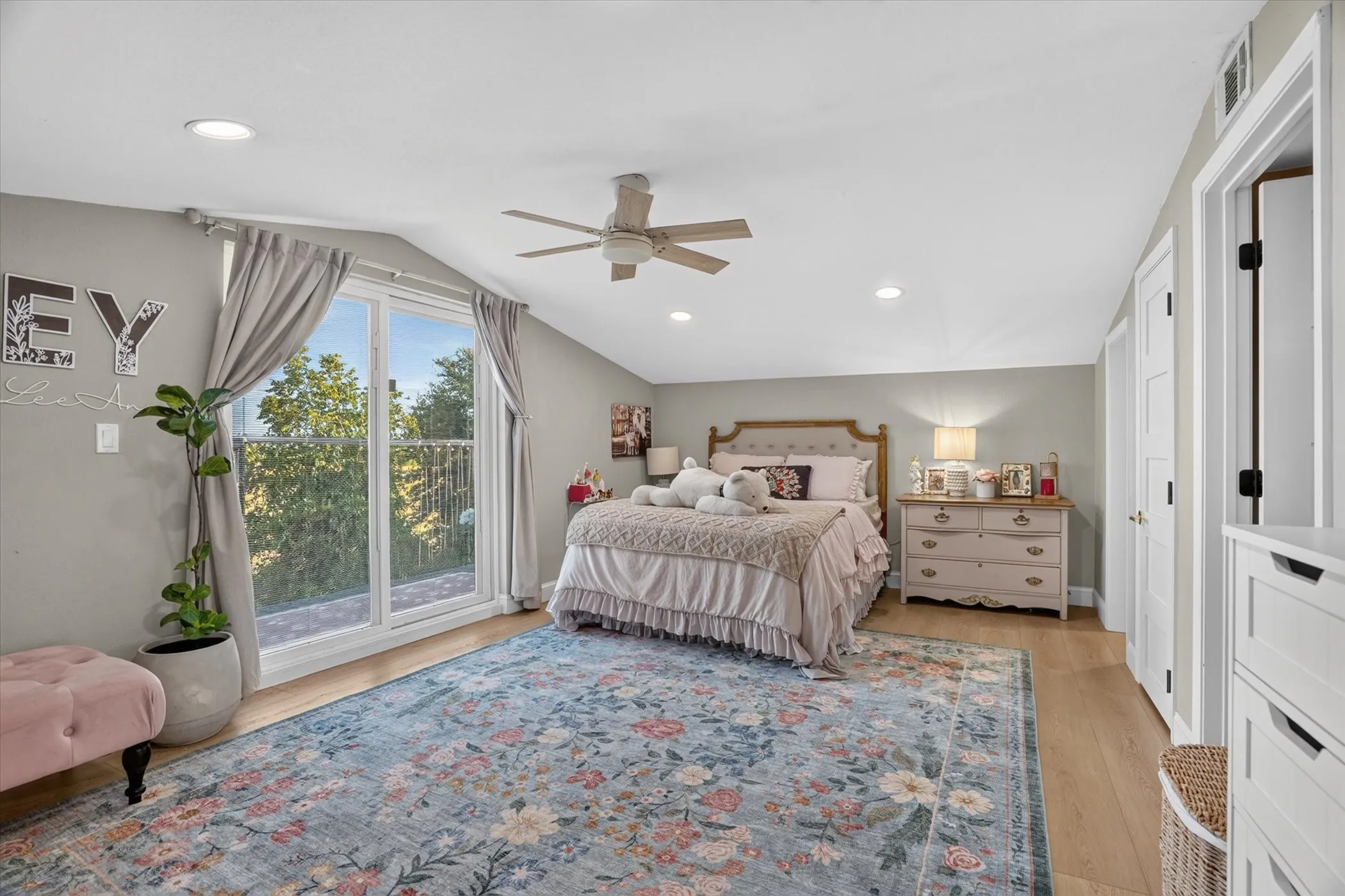 Sliding glass doors with balcony access, wood-finish flooring, recessed lighting, and a ceiling fan