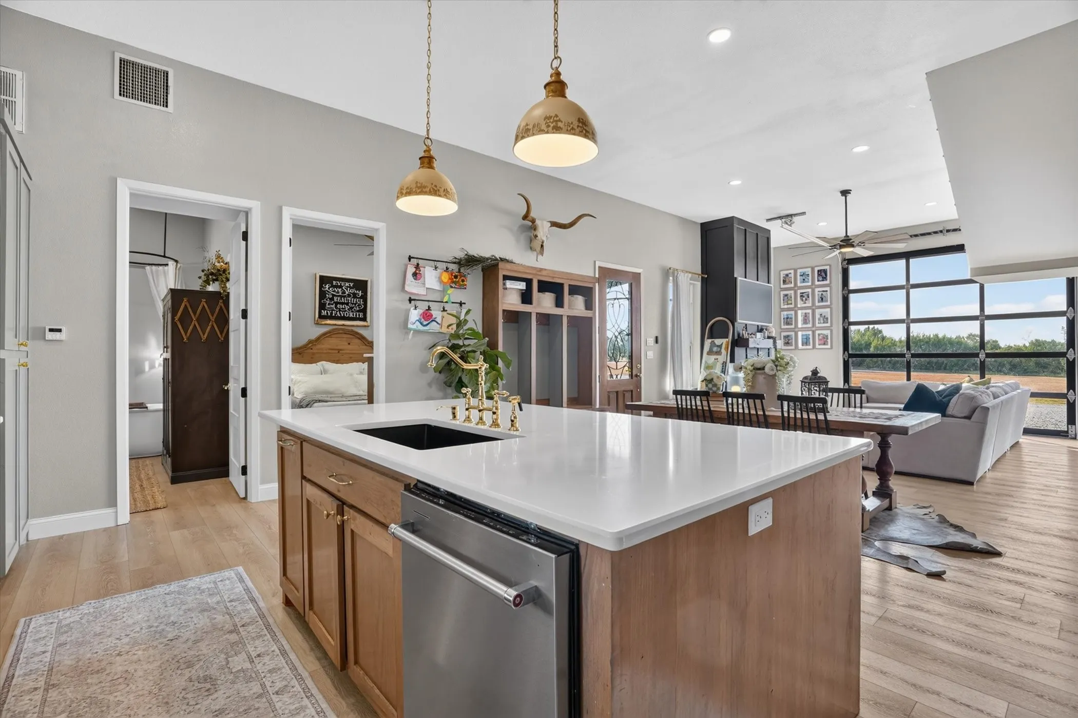 Central island with a solid surface countertop, integrated sink, and stainless steel dishwasher