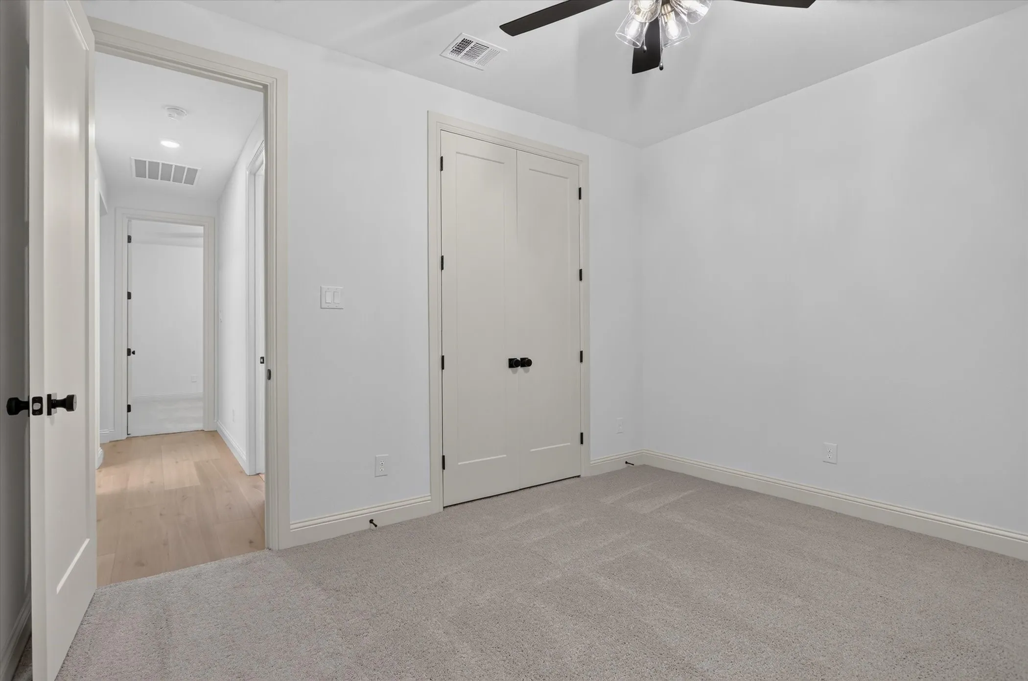 Neutral wall tones, recessed lighting, and a ceiling fan with integrated lighting