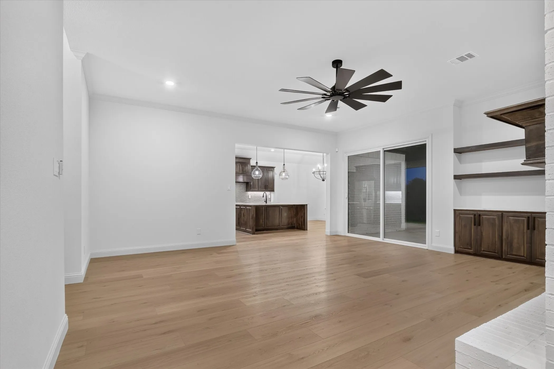 Open-concept living space with light wood-finish flooring, recessed lighting, and a modern ceiling fan