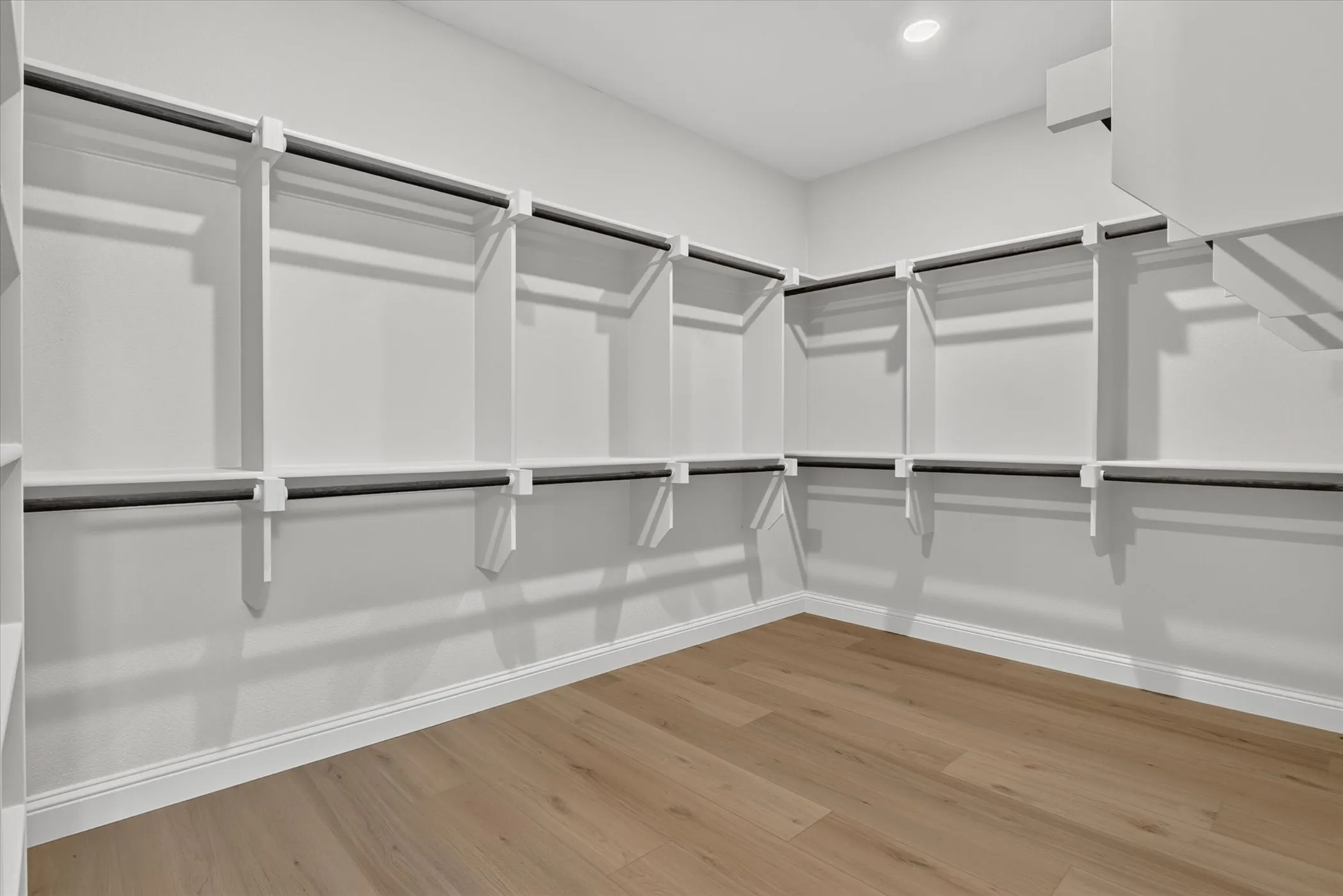 Built-in shelving with hanging rods, wood-finish flooring, recessed lighting
