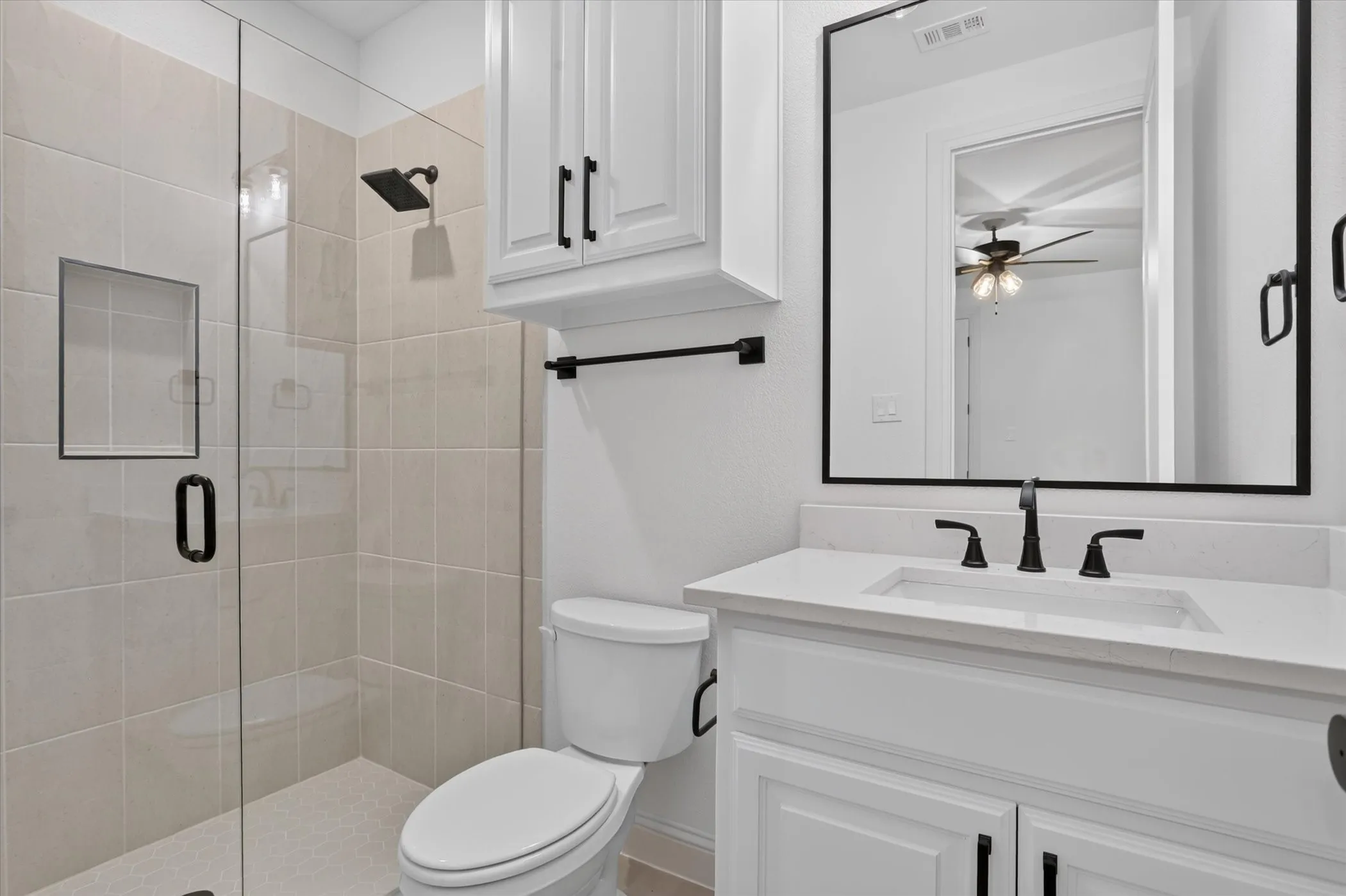 Walk-in shower with clear glass enclosure and tiled walls