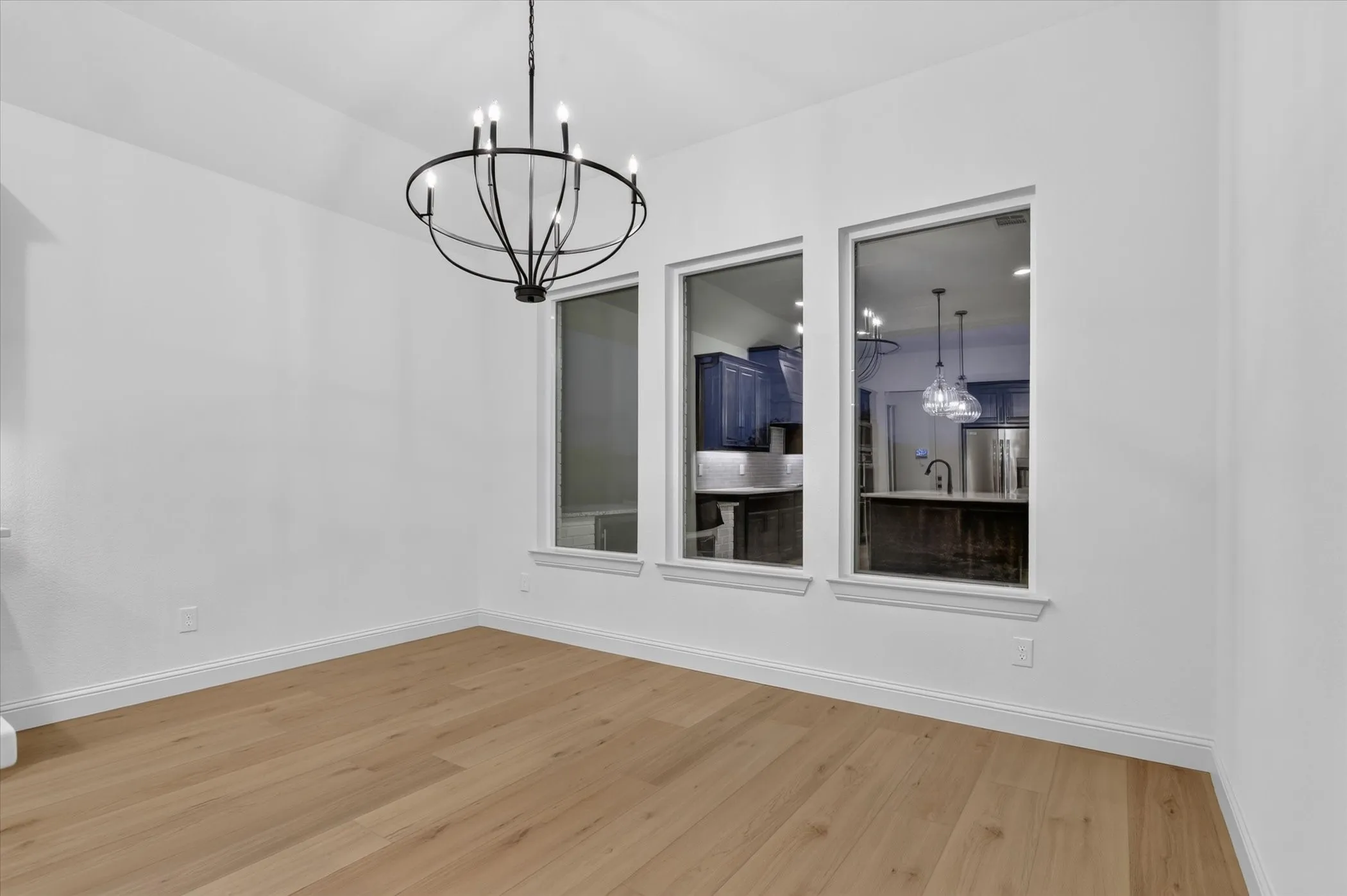 Spacious room with light-toned wood-finish flooring