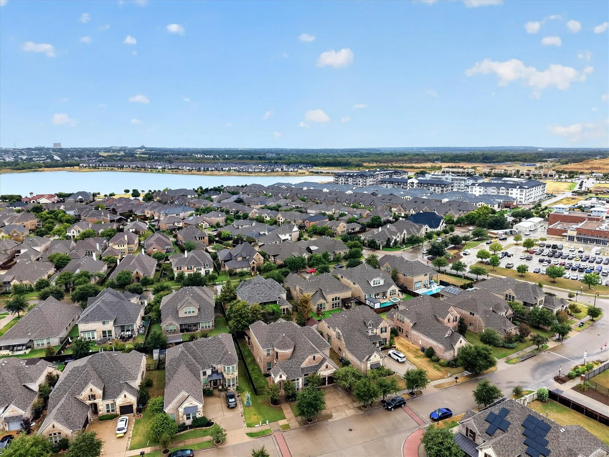 Expansive residential development featuring a large body of water, diverse architectural styles, and mature landscaping