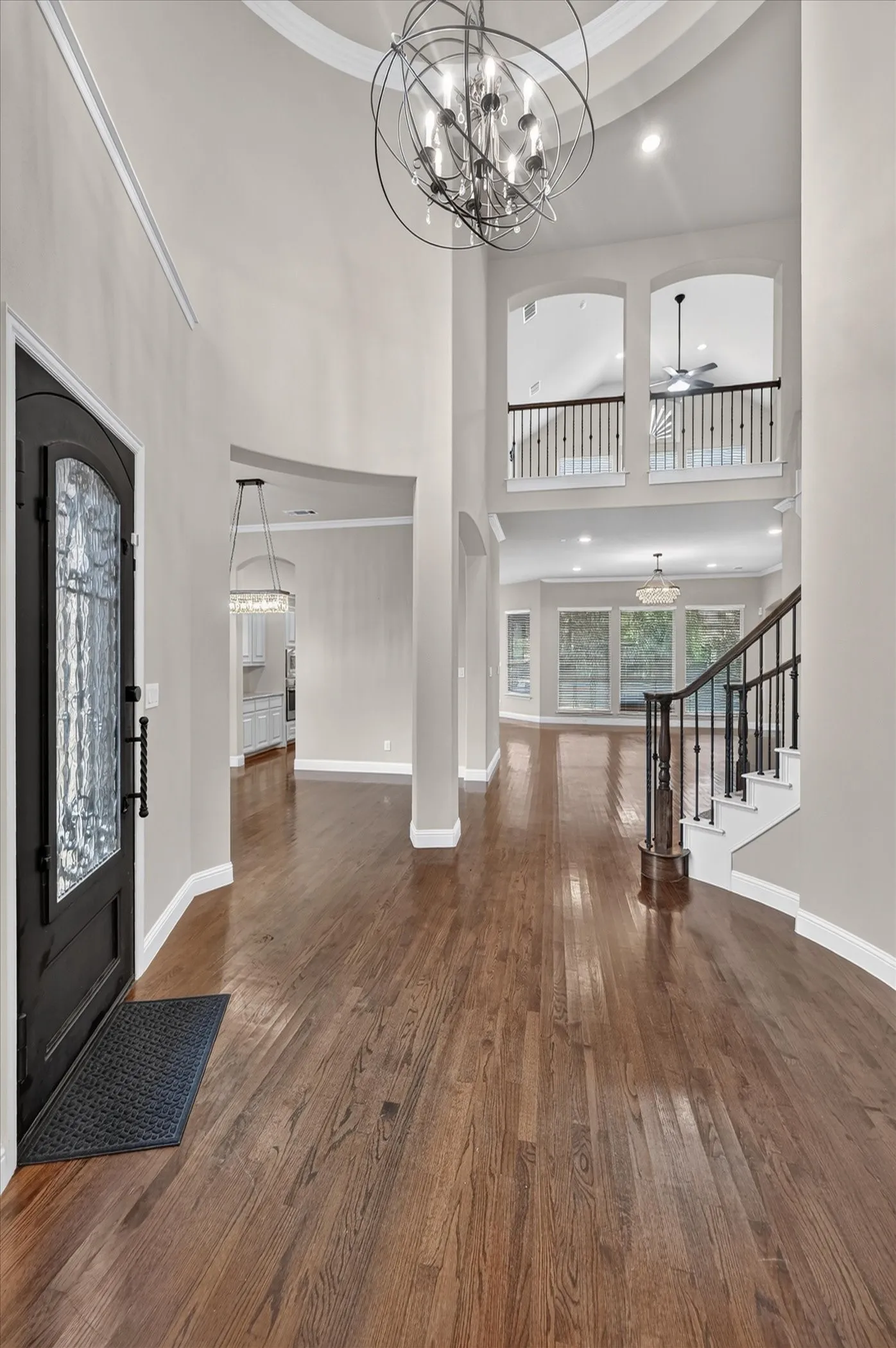 Two-story foyer with soaring ceilings and abundant natural light from arched transom windows