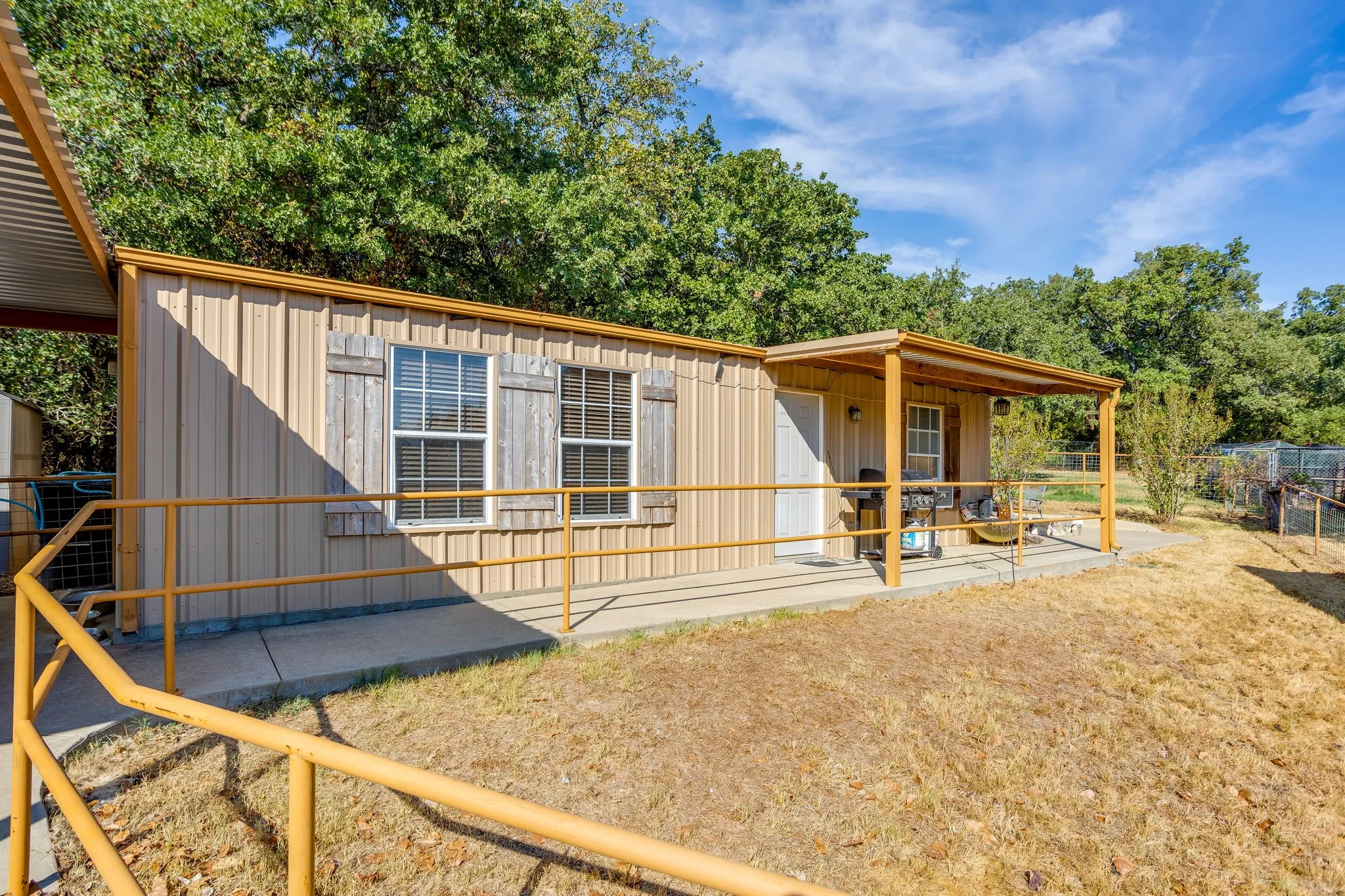Corrugated metal siding, covered porch, and solid wood shutters