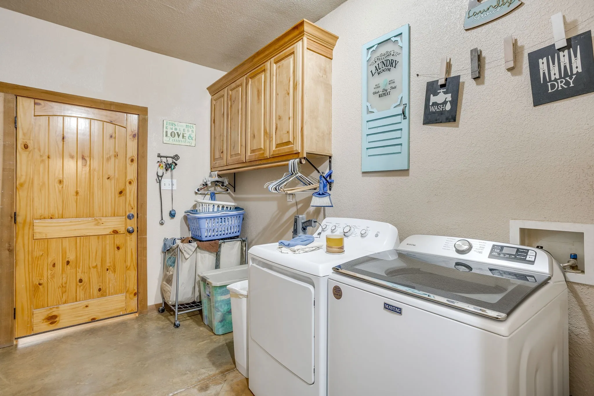 Wood-paneled door, upper built-in wood cabinetry, and neutral wall finish