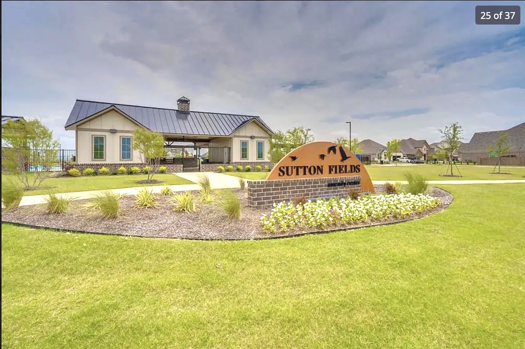 Community entrance signage with brick base and landscaping