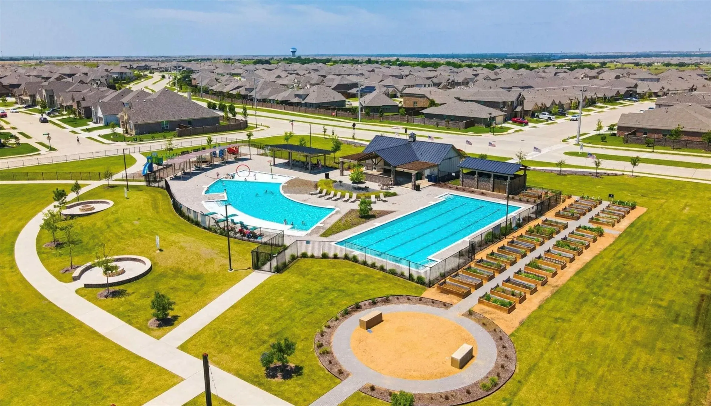 Community amenity center featuring two swimming pools, a covered pavilion, and individual garden plots