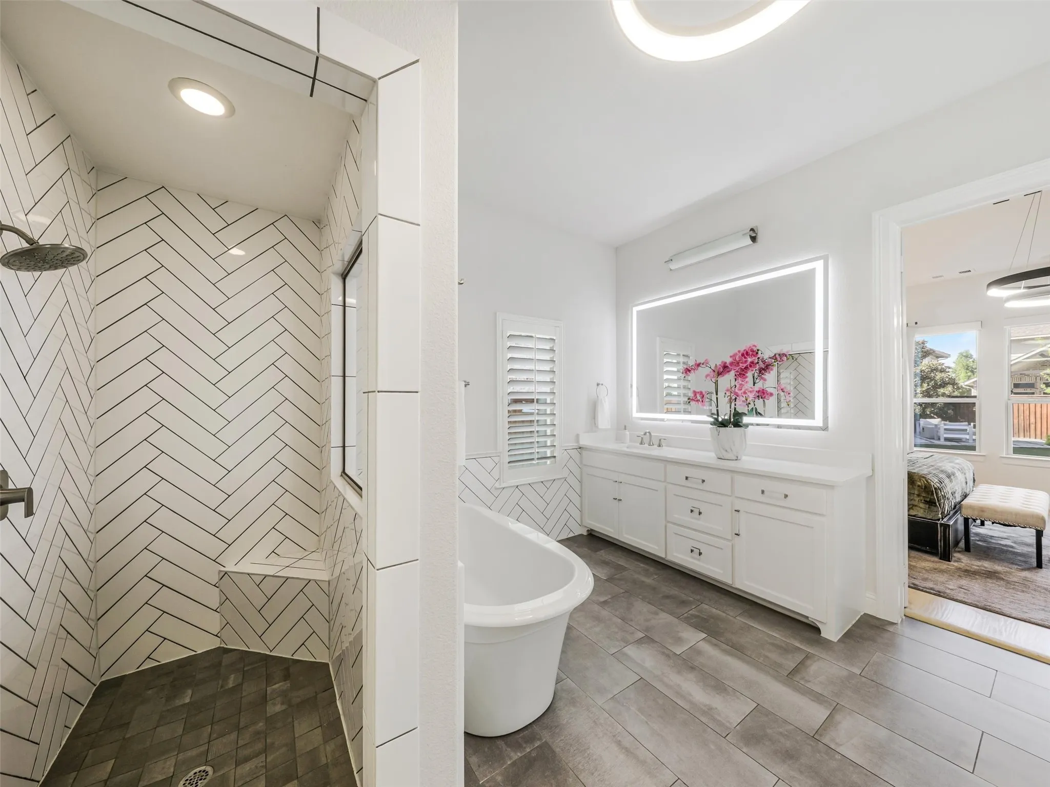 The spa-inspired bathroom features dual vanities with sinks, a soaking tub, an oversized walk-in shower, and separate his-and-hers walk-in closets. Thoughtful planning continues with direct access from the primary suite to the laundry room, making everyday routines exceptionally convenient. The oversized laundry room offers abundant storage along with dedicated space for an additional refrigerator or freezer. • White oak flooring
• Vaulted ceilings
• Custom accent wall