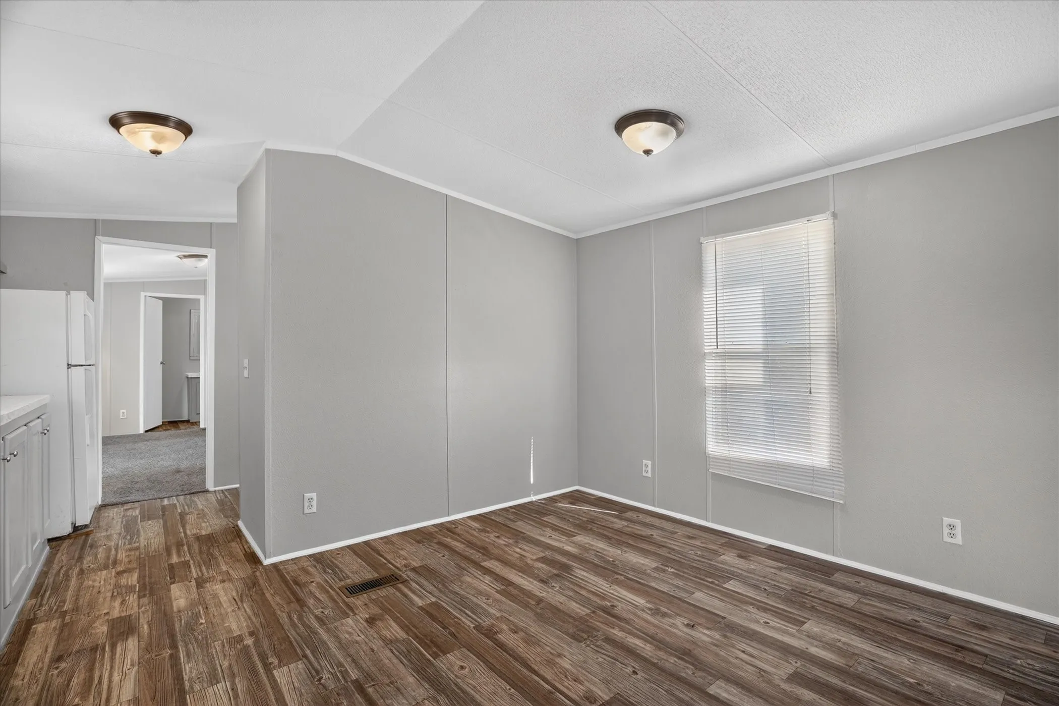 Wood-finish flooring throughout, complemented by light gray wall panels and white trim