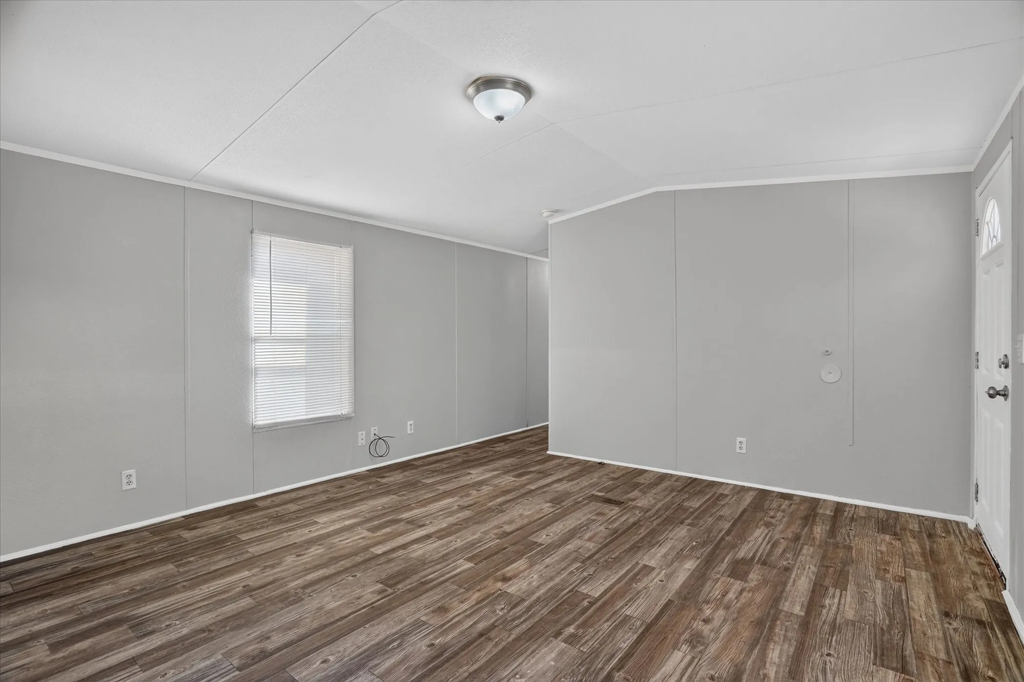 Wood-finish flooring with light gray wall panels and white trim