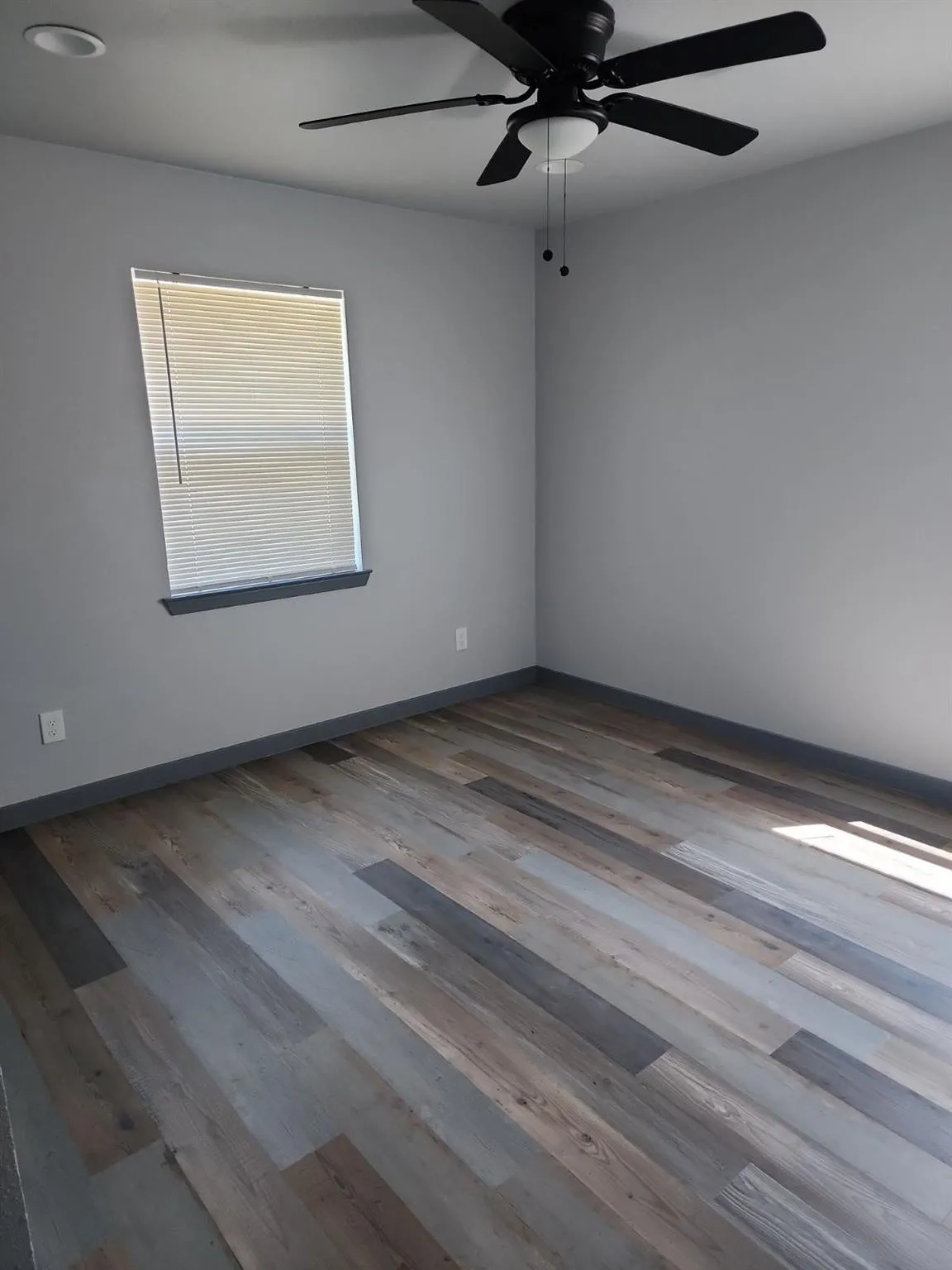 Recessed ceiling lighting, ceiling fan with integrated light, wood-finish flooring, and window with blinds