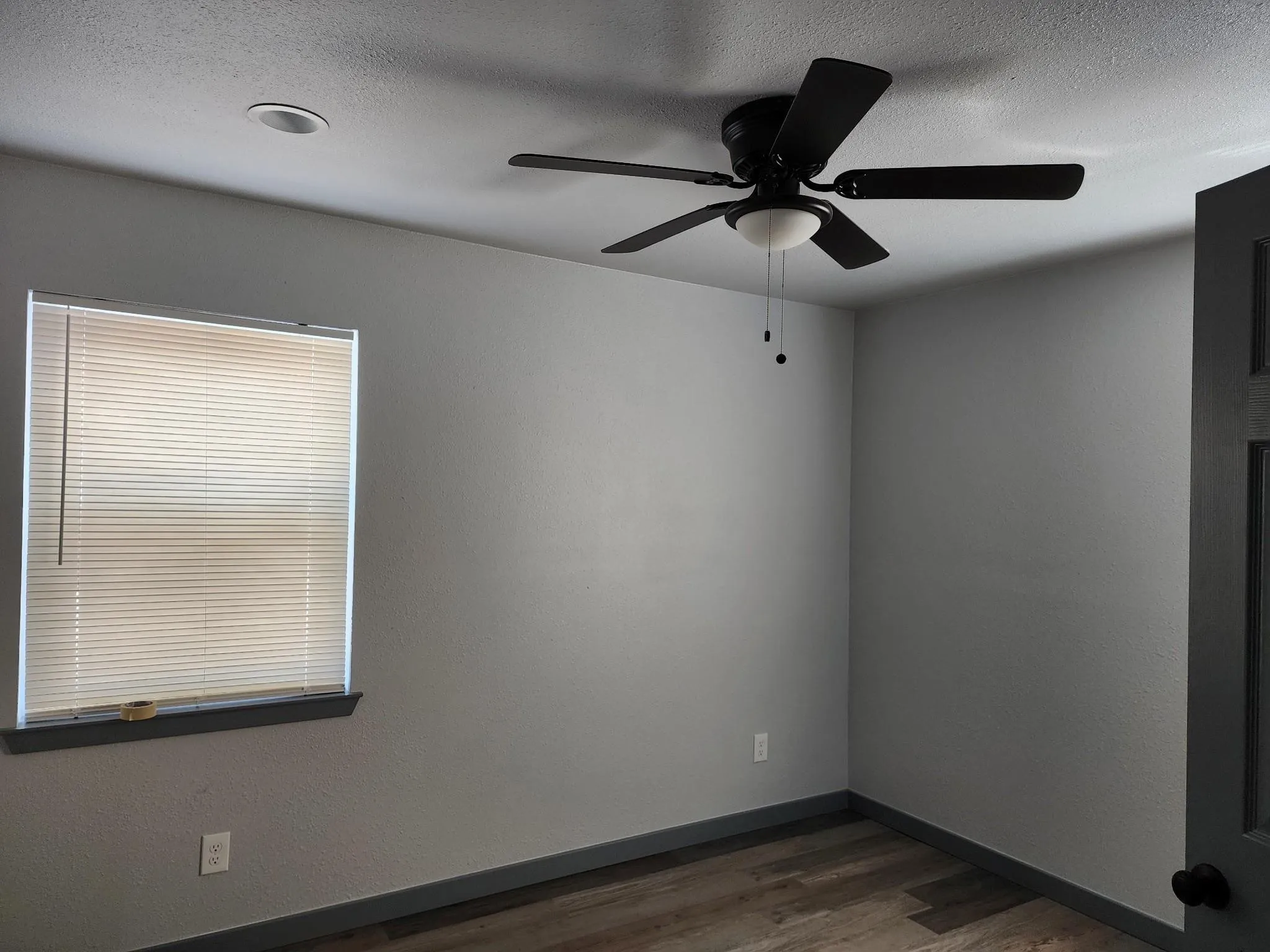 Room featuring wood-finish flooring, a ceiling fan with integrated lighting, a recessed ceiling light, and a window with blinds