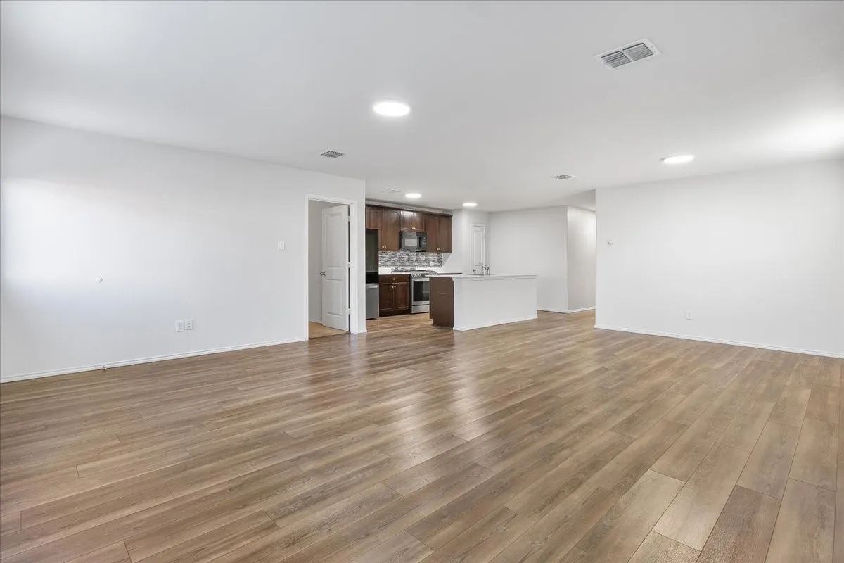 Open-concept living area featuring wood-finish flooring, recessed lighting, and a white interior paint scheme