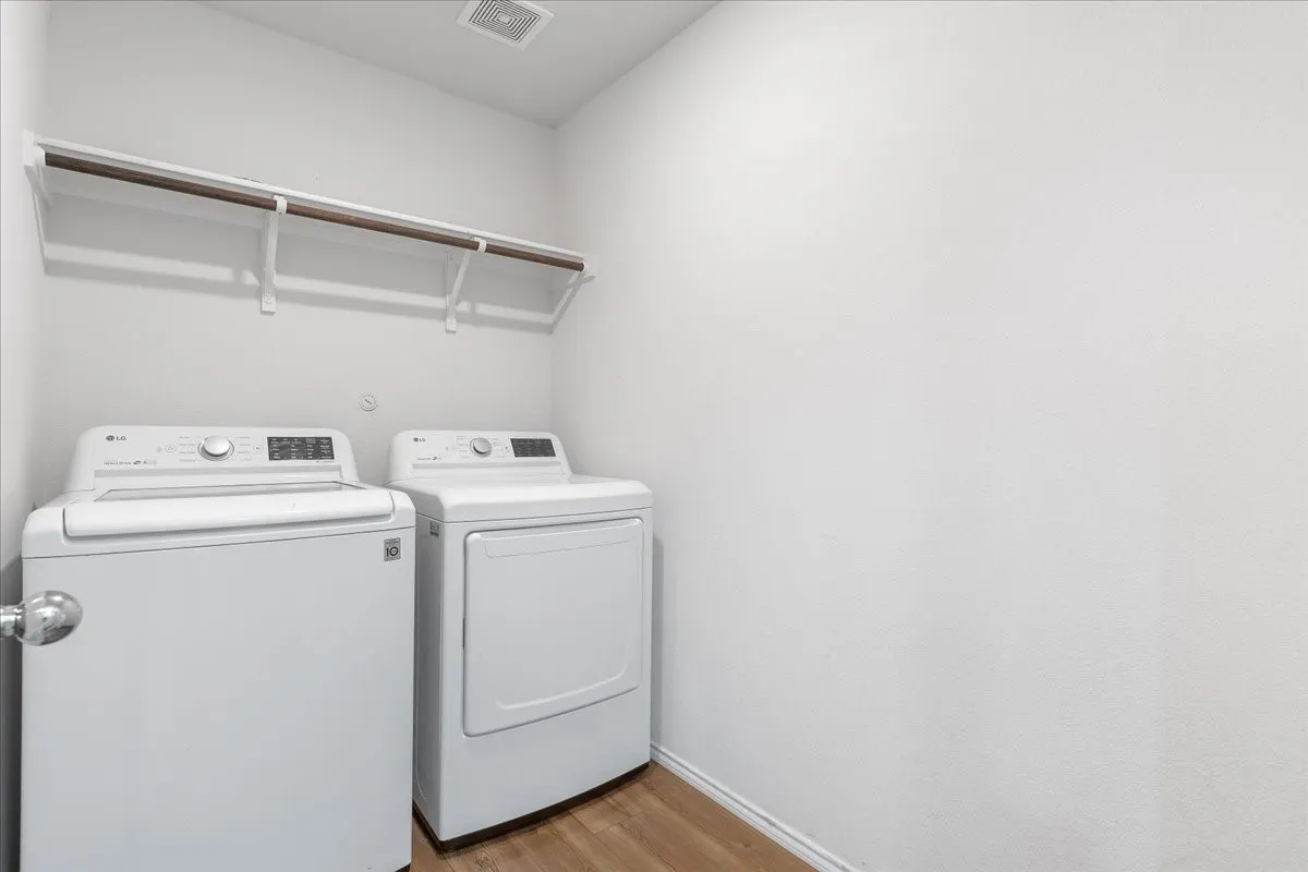 Dedicated utility area featuring wood-finish flooring and a built-in hanging rod