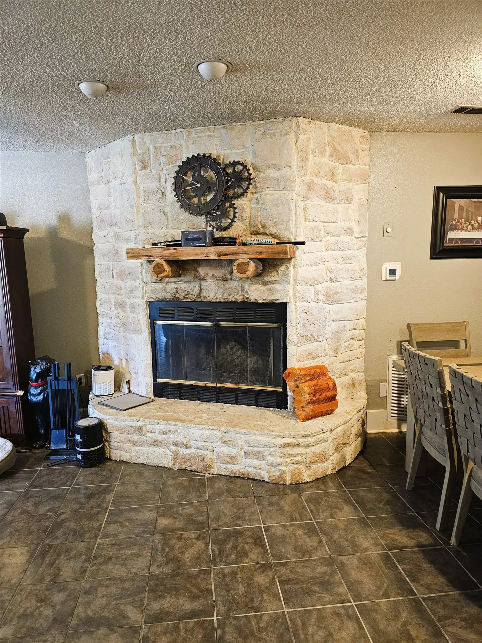 Corner fireplace featuring a stone surround, an integrated hearth, and a wooden mantel