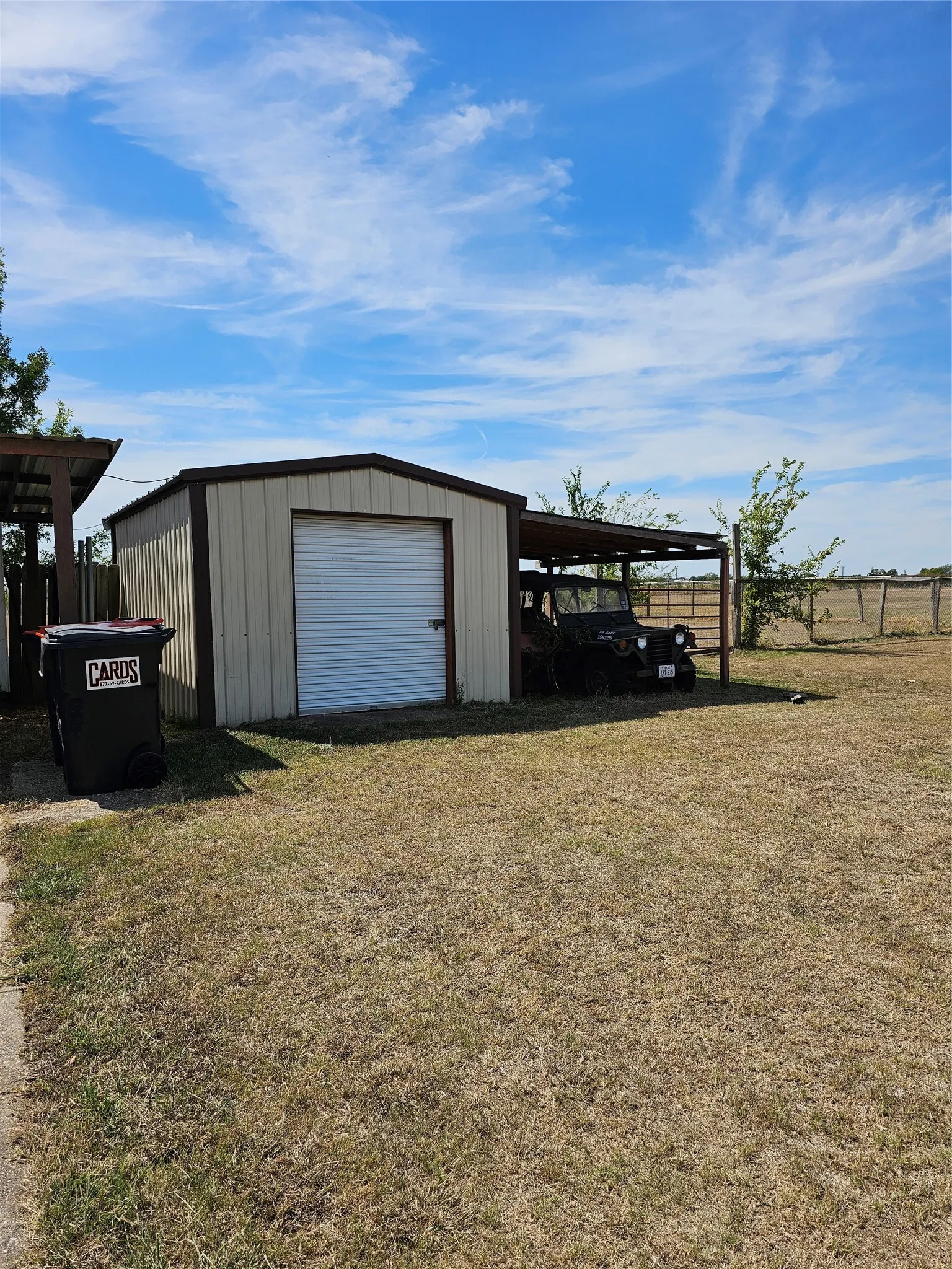 Metal storage building with a roll-up door and an attached covered carport