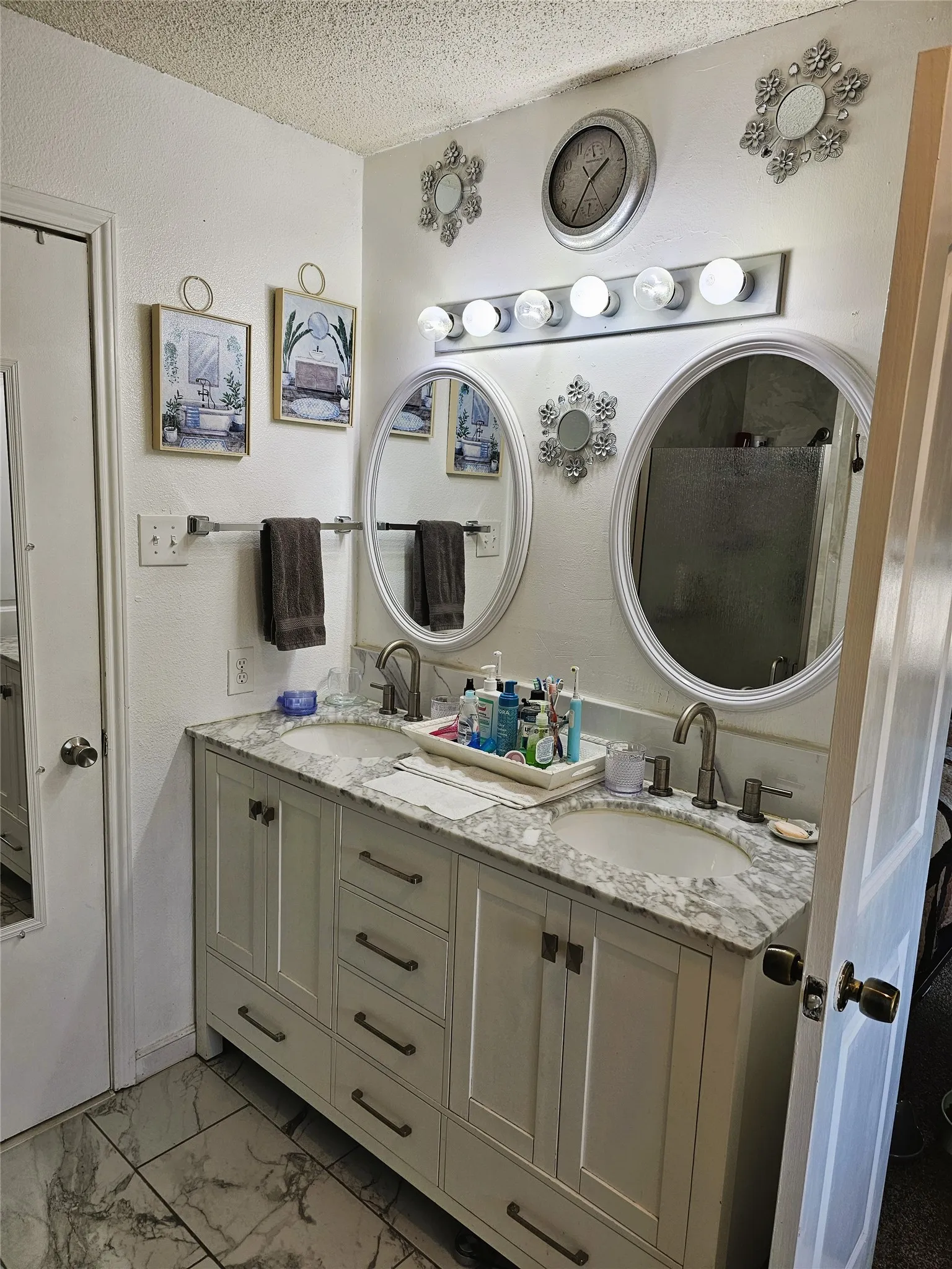 Double vanity with a light-toned countertop, dual undermount sinks, and white cabinetry
