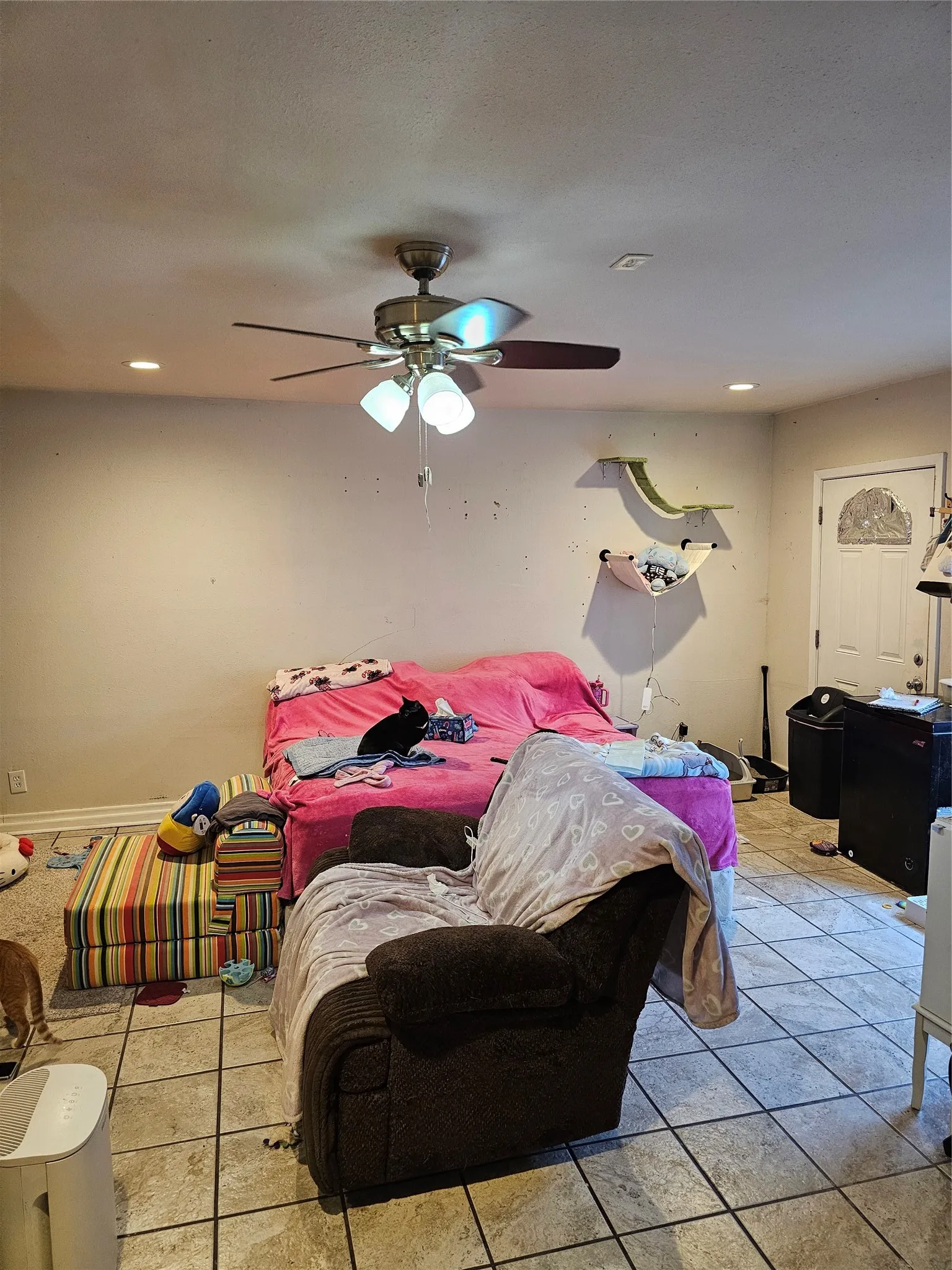 Recessed lighting and a ceiling fan with light kit illuminate the room