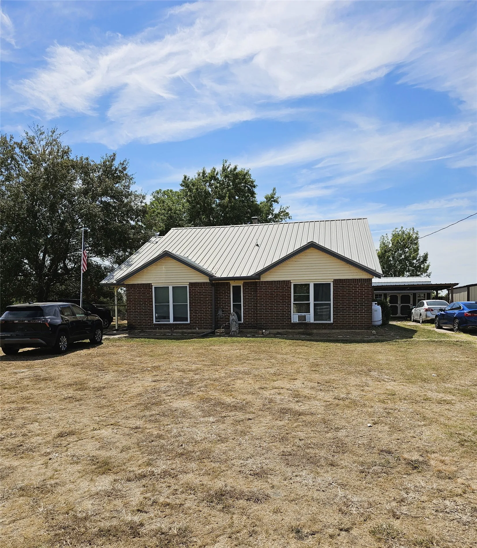 Brick and siding exterior with a pitched metal roof