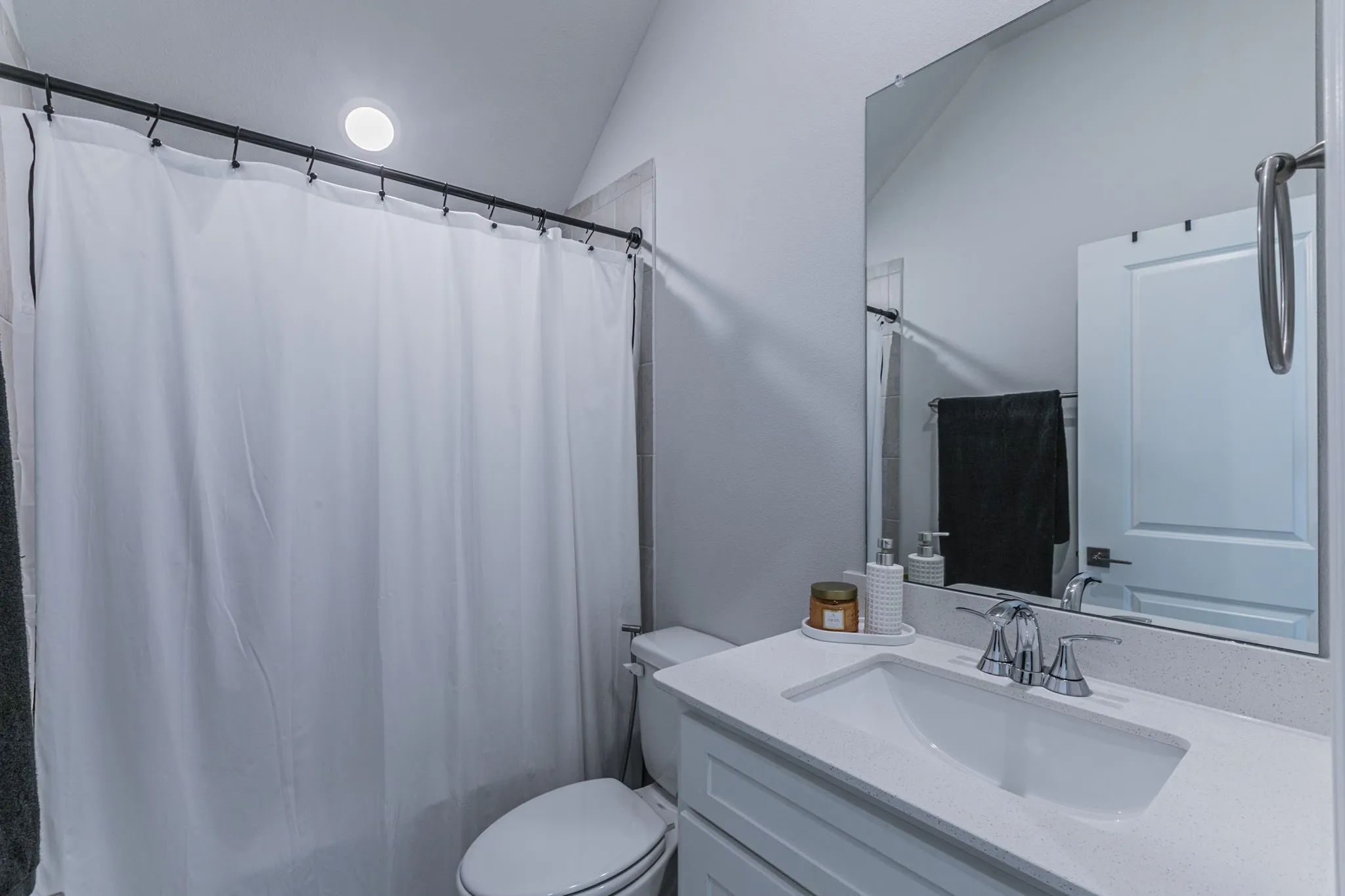 Full bathroom with vanity, vaulted ceiling, and shower / bath combo